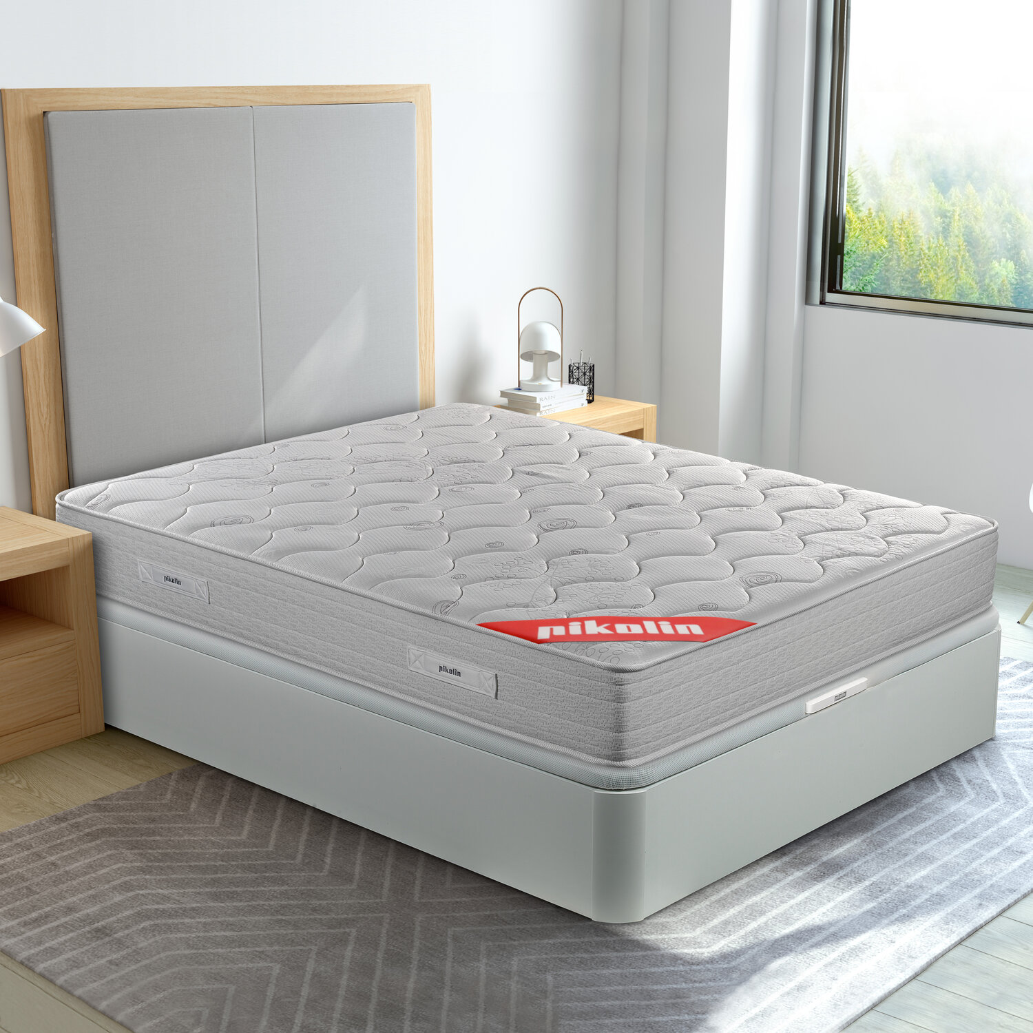 Una cama gris con colchón y marco de madera en una habitación luminosa.