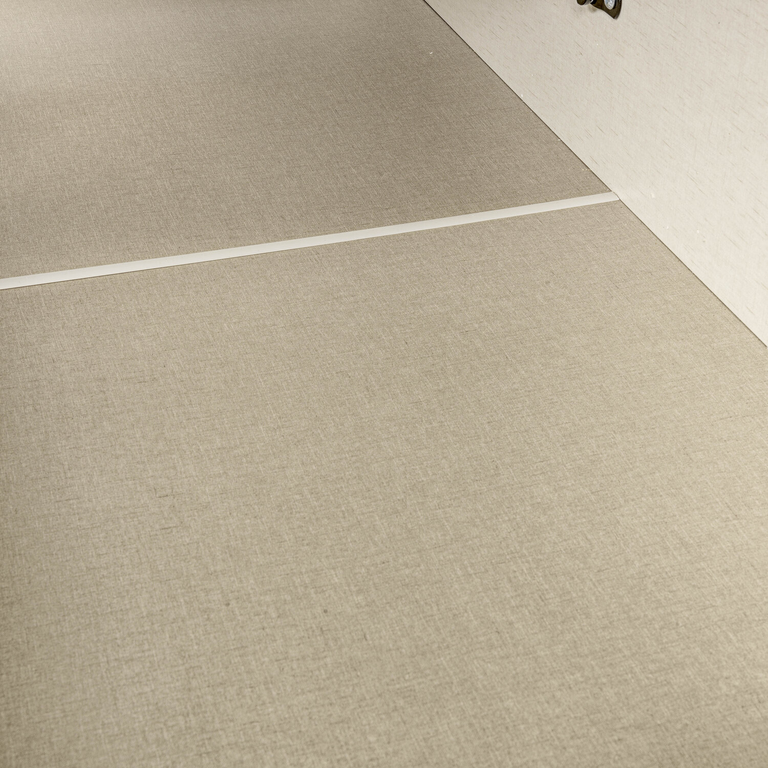 Un primer plano de tela beige con una línea blanca que la divide.