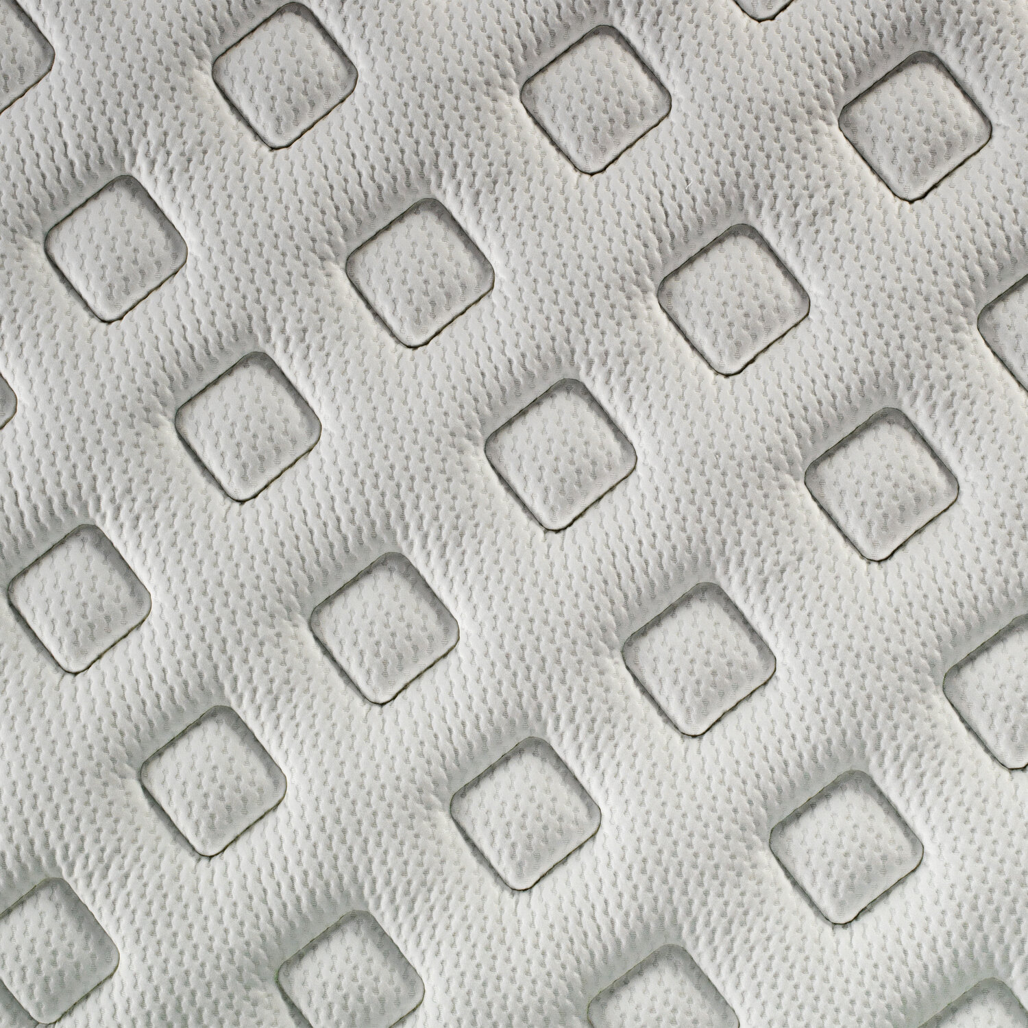 Tejido blanco con patrón de diamantes y cuadrados acolchados.