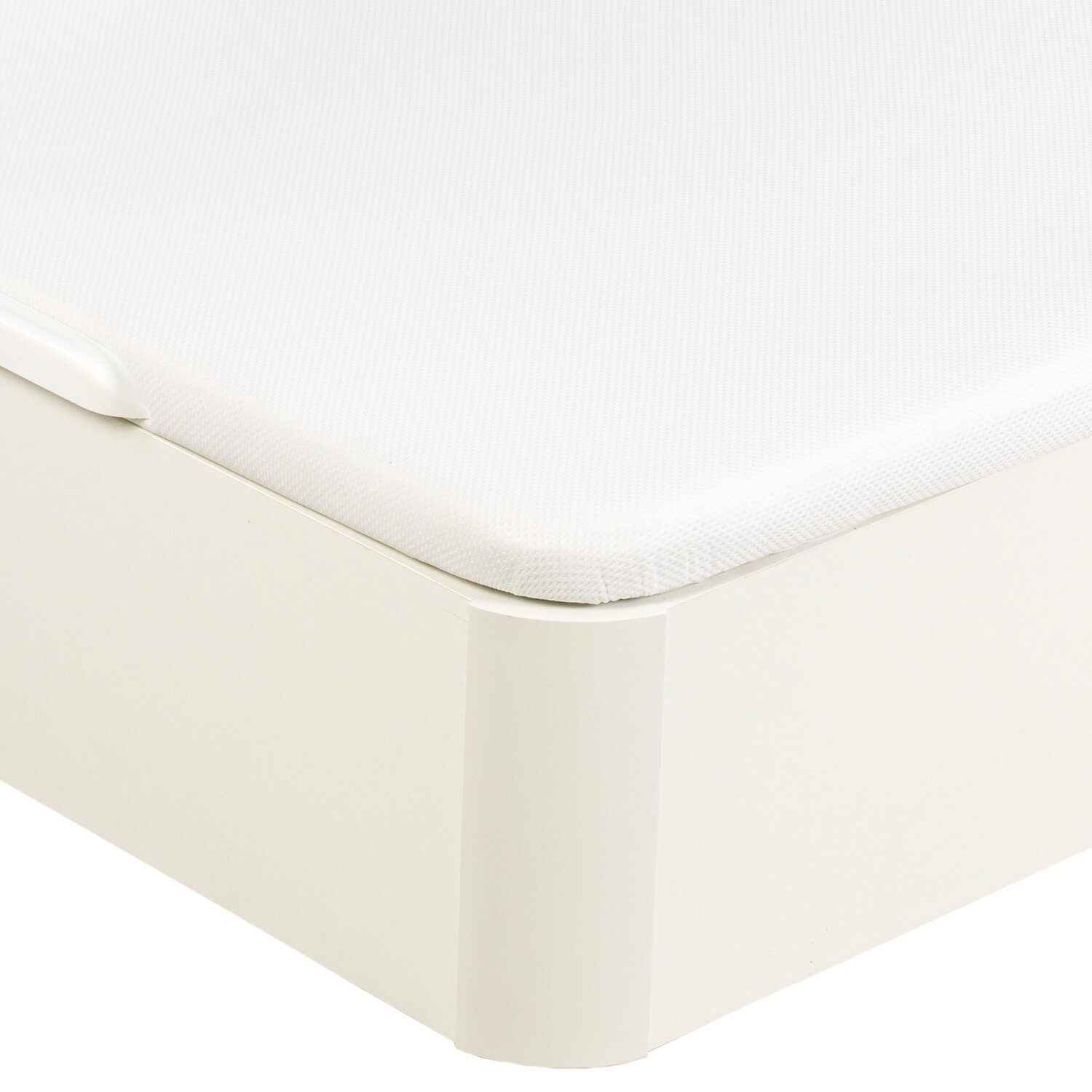 Un colchón blanco descansa sobre un marco de cama color crema.