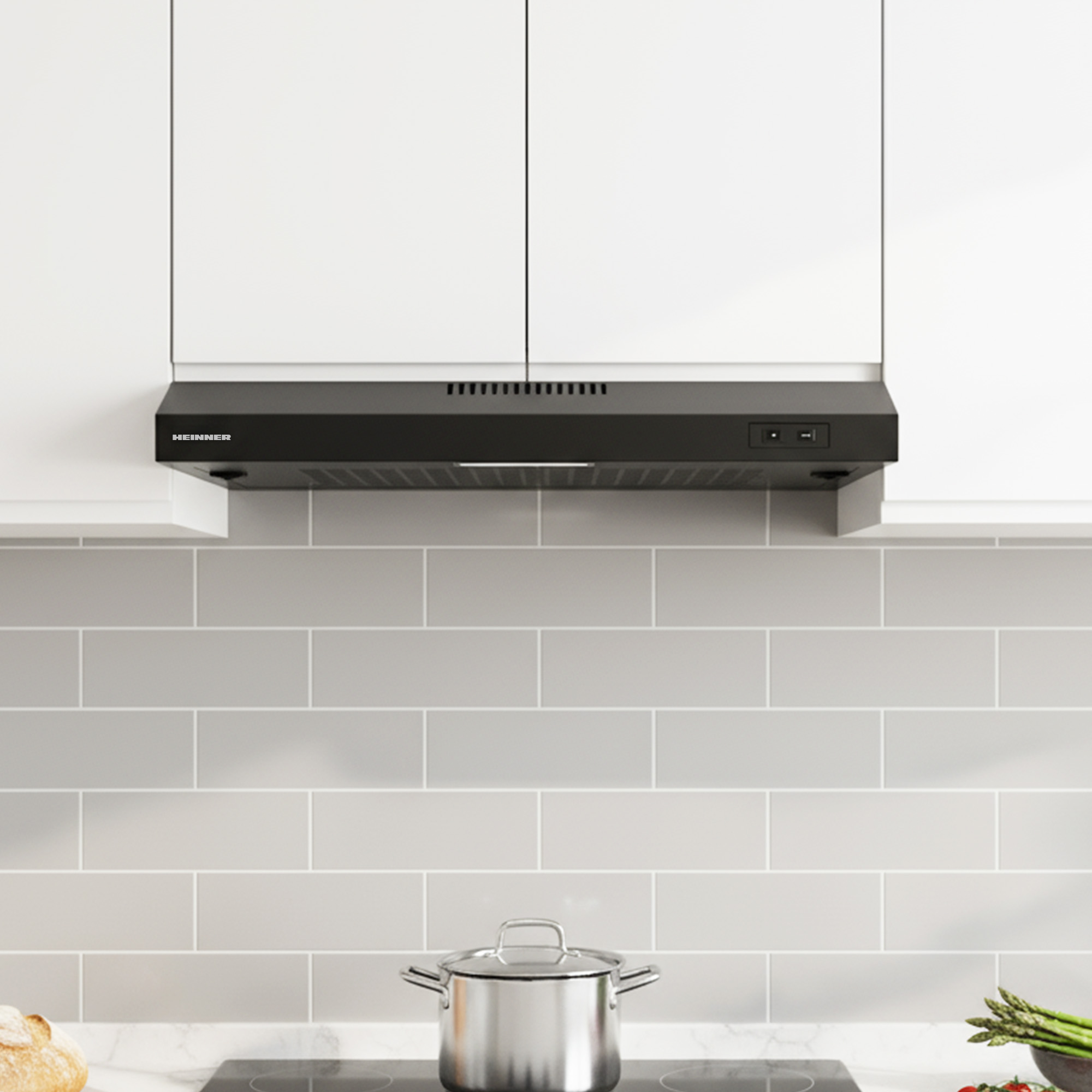 A black range hood above a stovetop with a pot and bread.