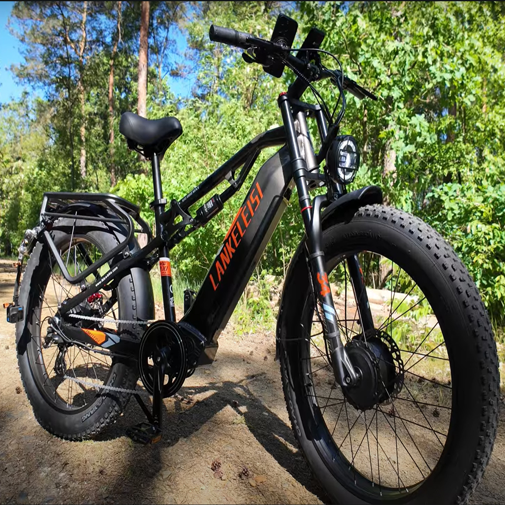 Bicicleta eléctrica negra con neumáticos anchos y suspensión en el bosque.