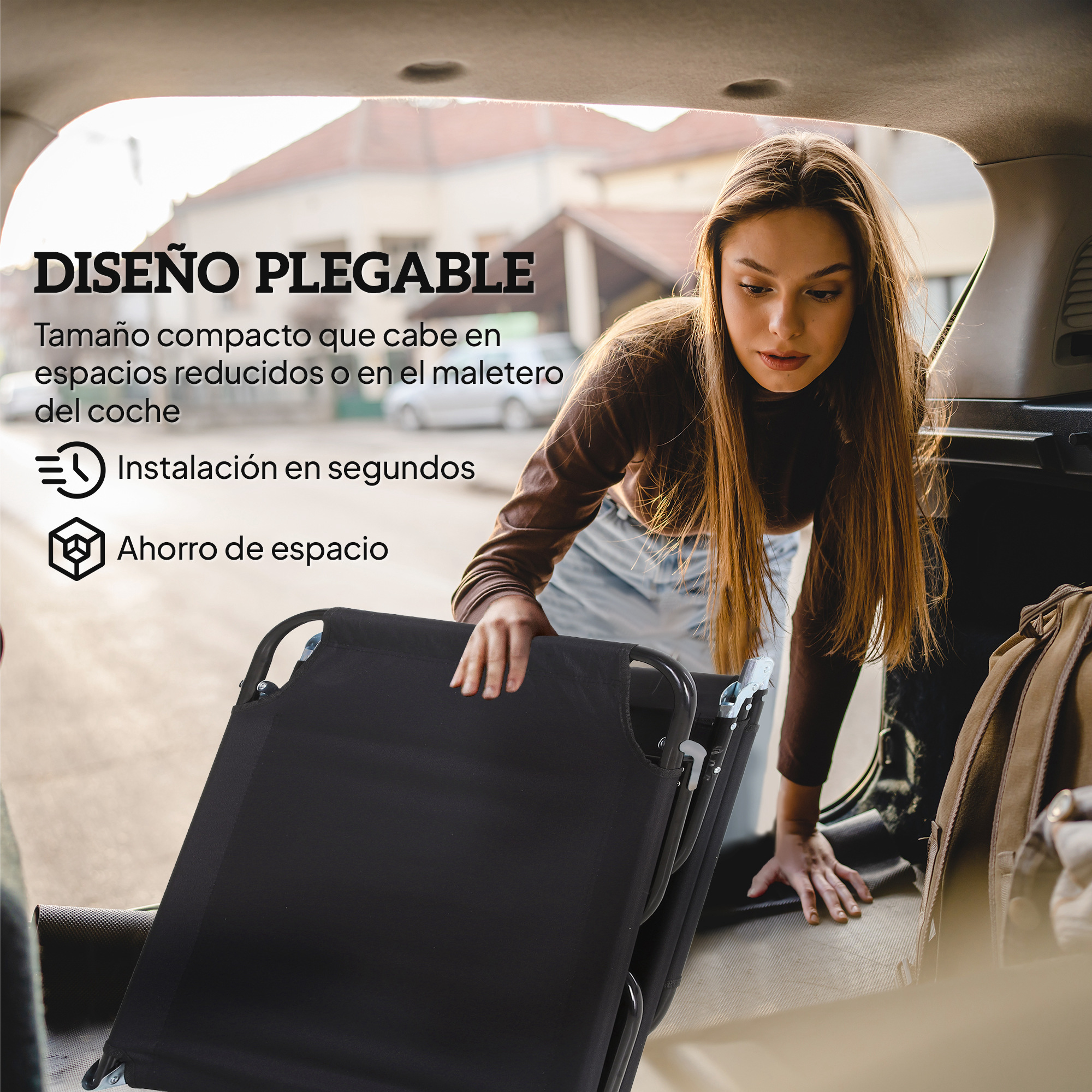 Una mujer carga una camilla plegable negra en un coche.