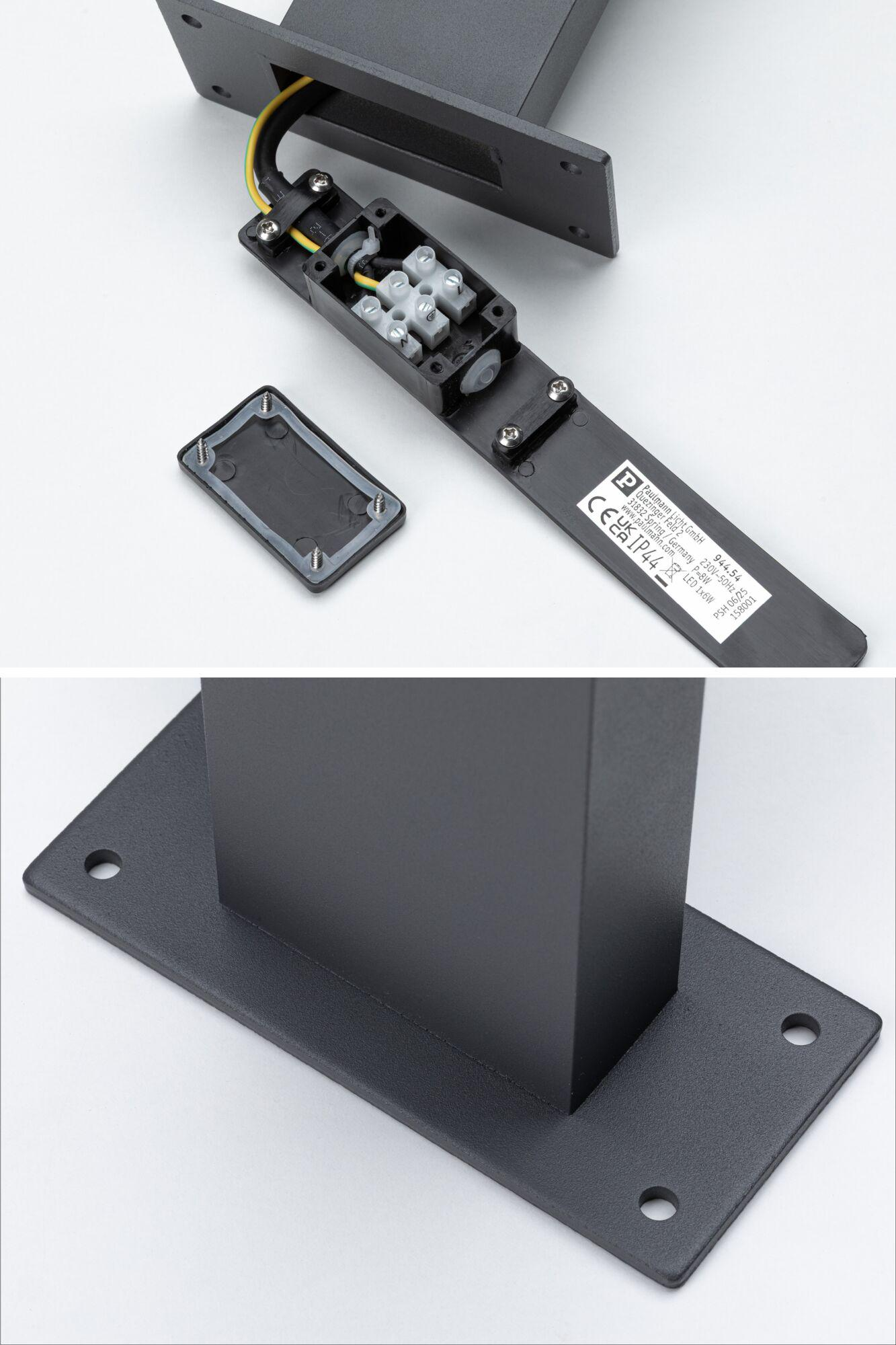 Czarna podstawa lampy ze skrzynką elektryczną i przewodami, zbliżenie.