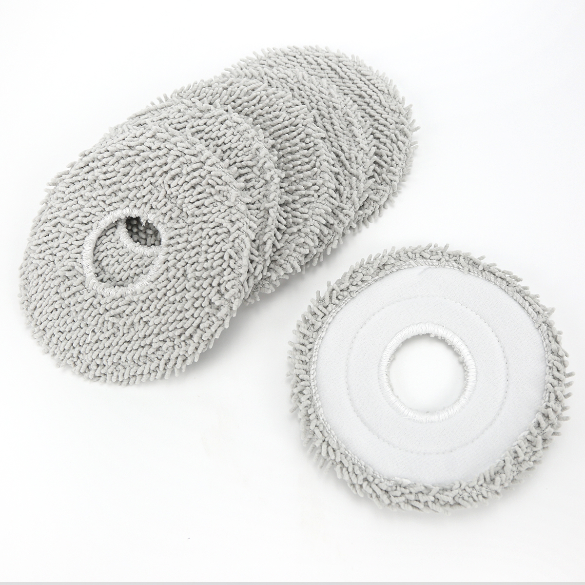Kilka szarych, okrągłych nakładek mopujących z mikrofibry z centralnym otworem na białym tle.