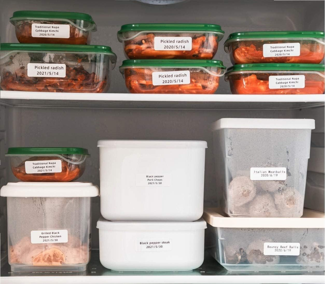 Vari contenitori per alimenti riempiti con kimchi, polpette e carne. Etichettati con contenuto e date.