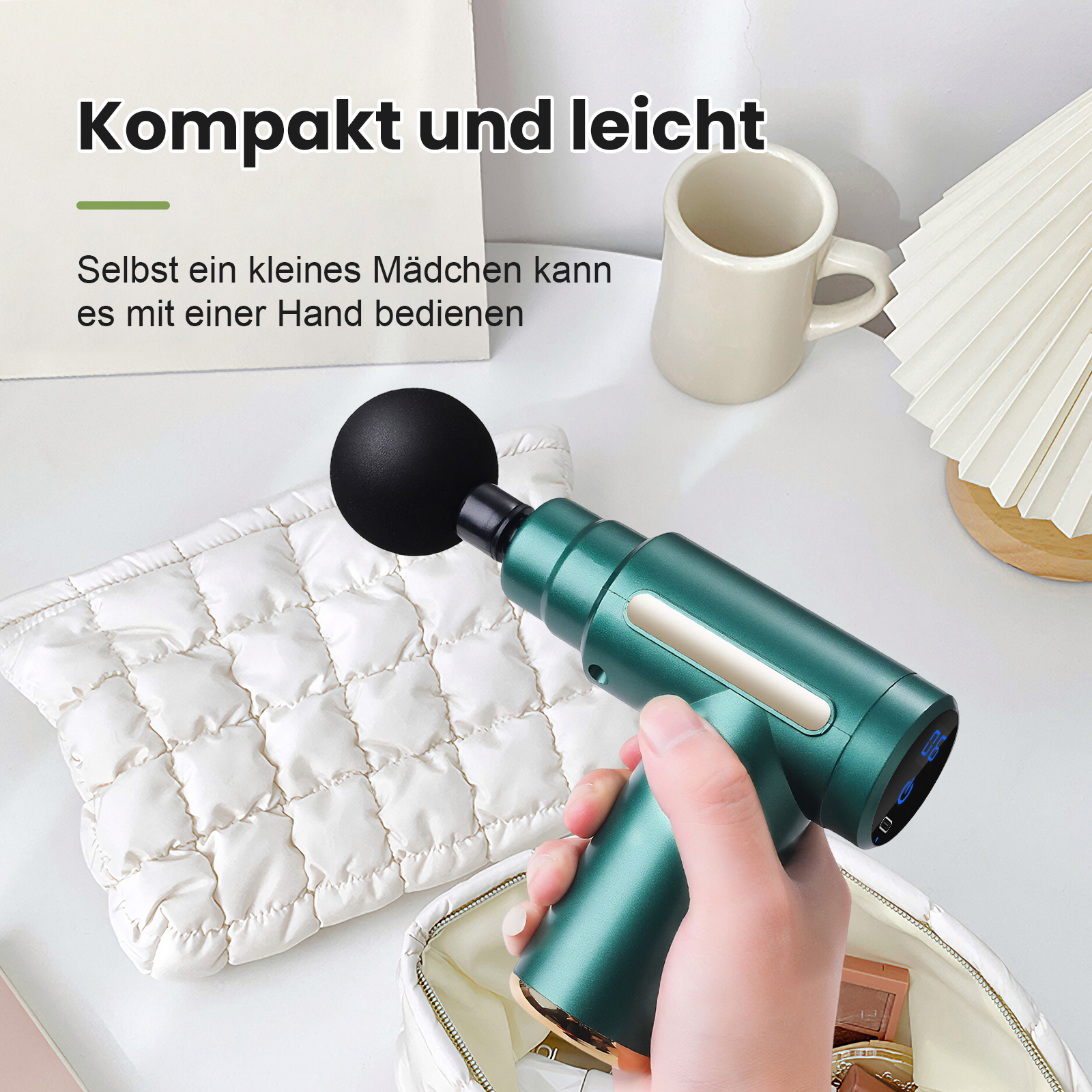 Eine Hand hält eine grüne Massagepistole auf einer weißen Stepptasche.