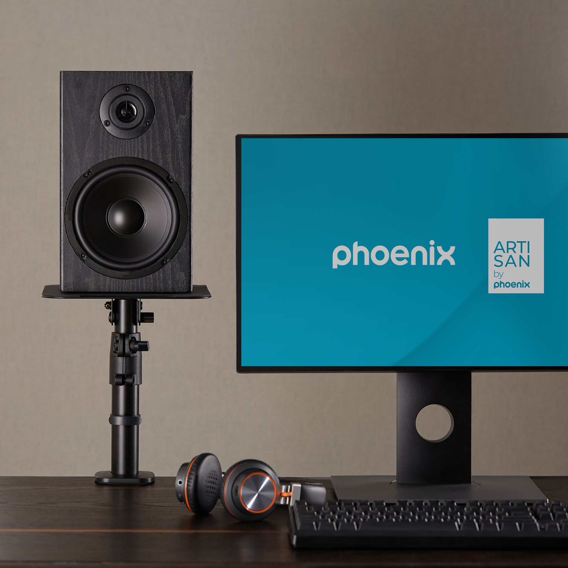 Altavoz negro en soporte junto a monitor con pantalla azul.