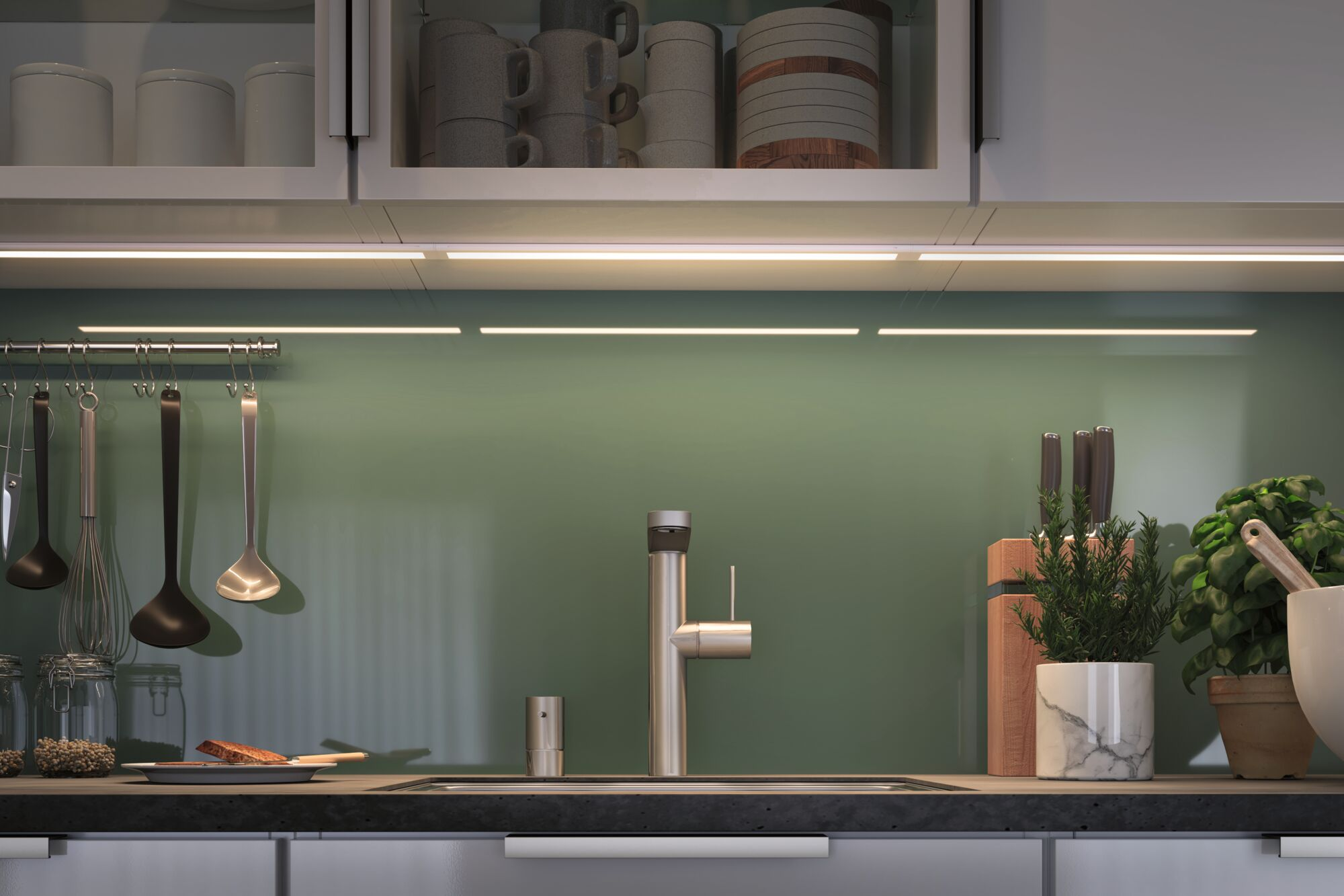 Moderne Küche mit grünem Fliesenspiegel, Chromarmatur und Utensilien.