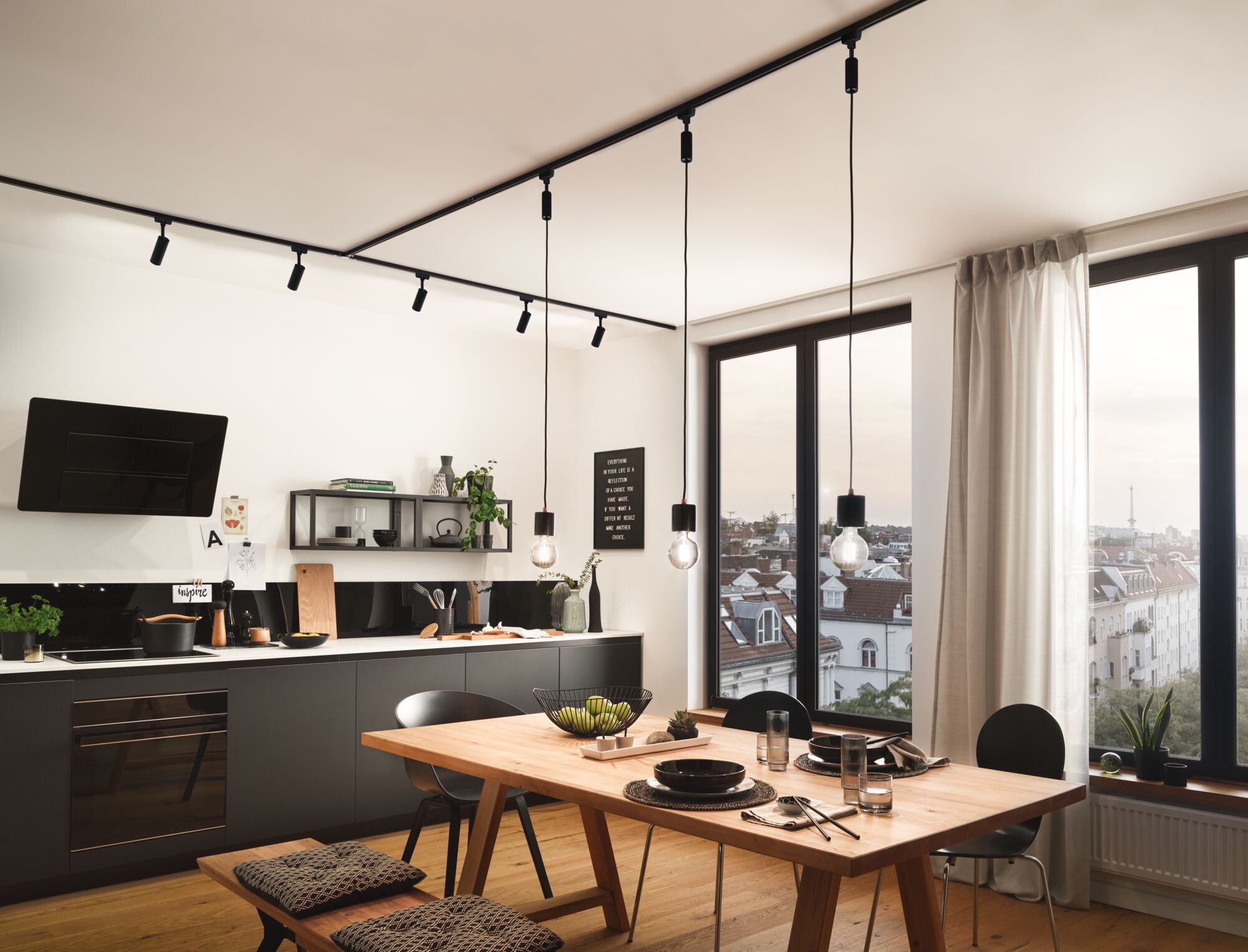 Nowoczesna kuchnia z ciemnymi szafkami, wyspą i jadalnią z widokiem na miasto.