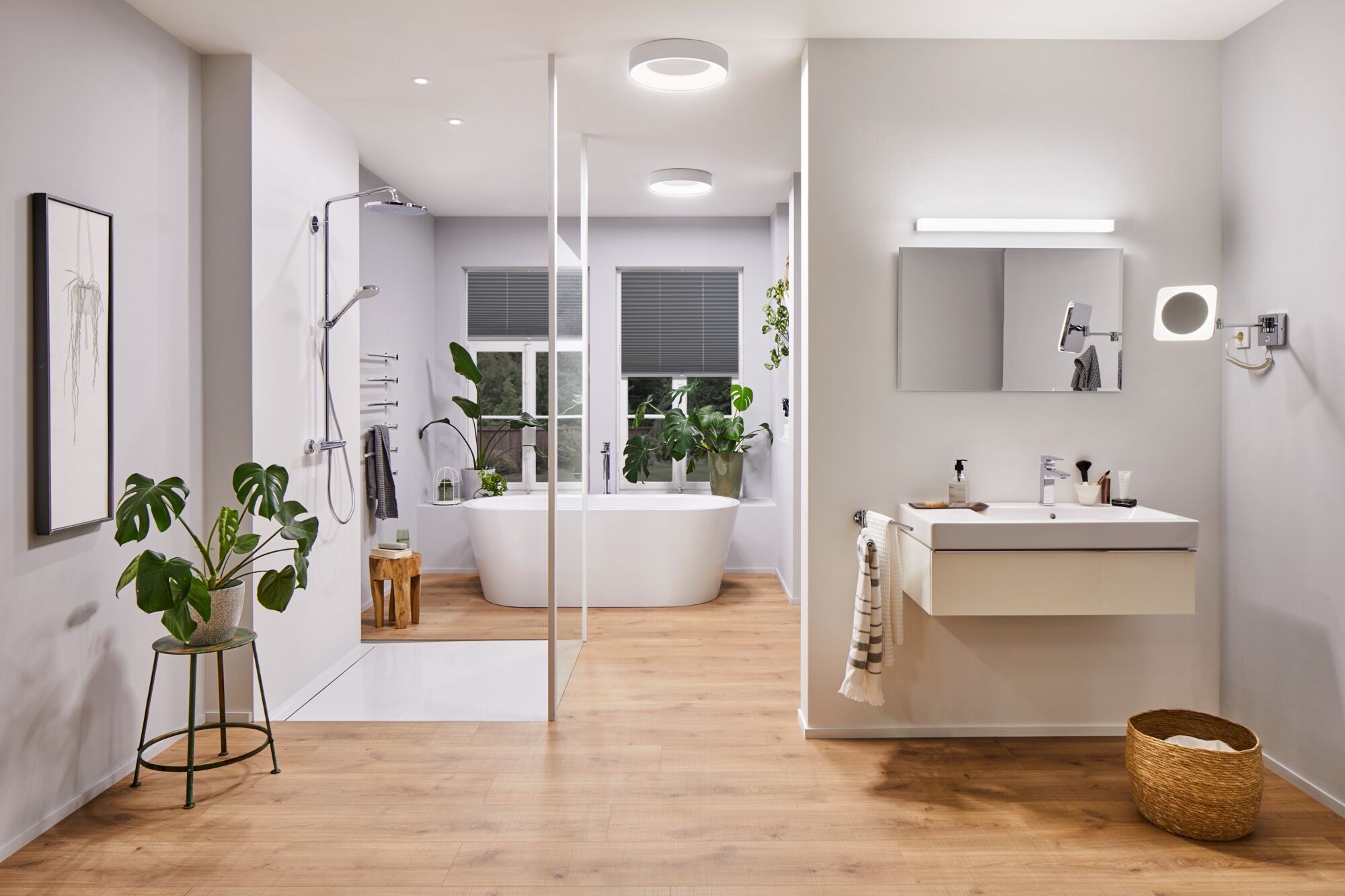 Nowoczesna łazienka z wolnostojącą wanną, prysznicem i szafką podumywalkową.