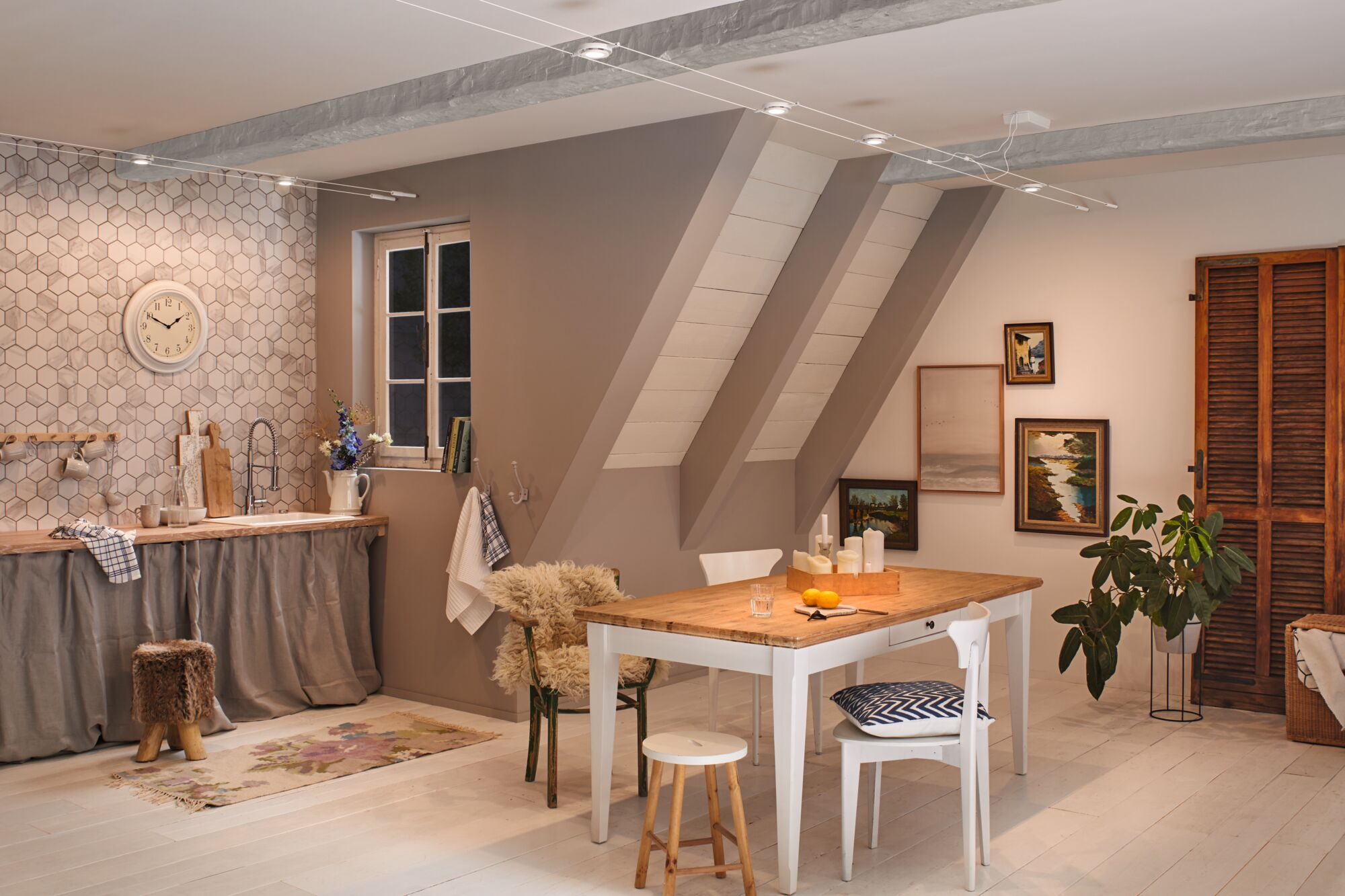 Coin repas cuisine: table en bois, chaises blanches, tabouret, horloge, fenêtre.