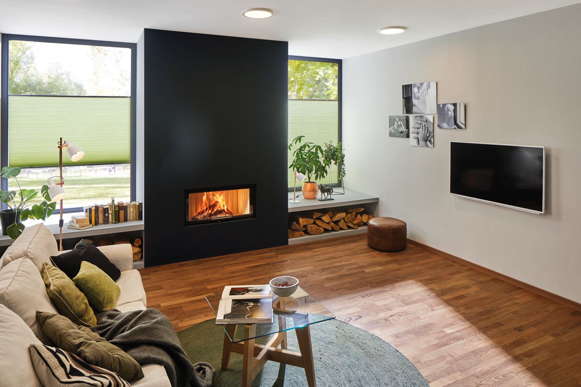 Ein Wohnzimmer mit Kamin, Sofa, Couchtisch und Fernseher.