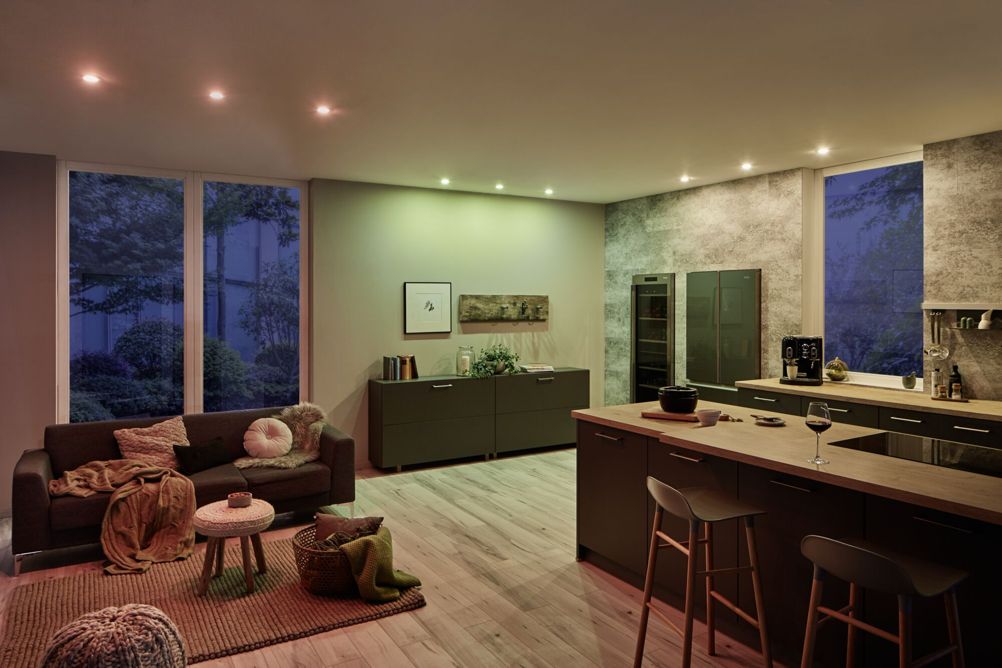 Soggiorno moderno con cucina, divano, tavolino, bar e pavimento in legno.