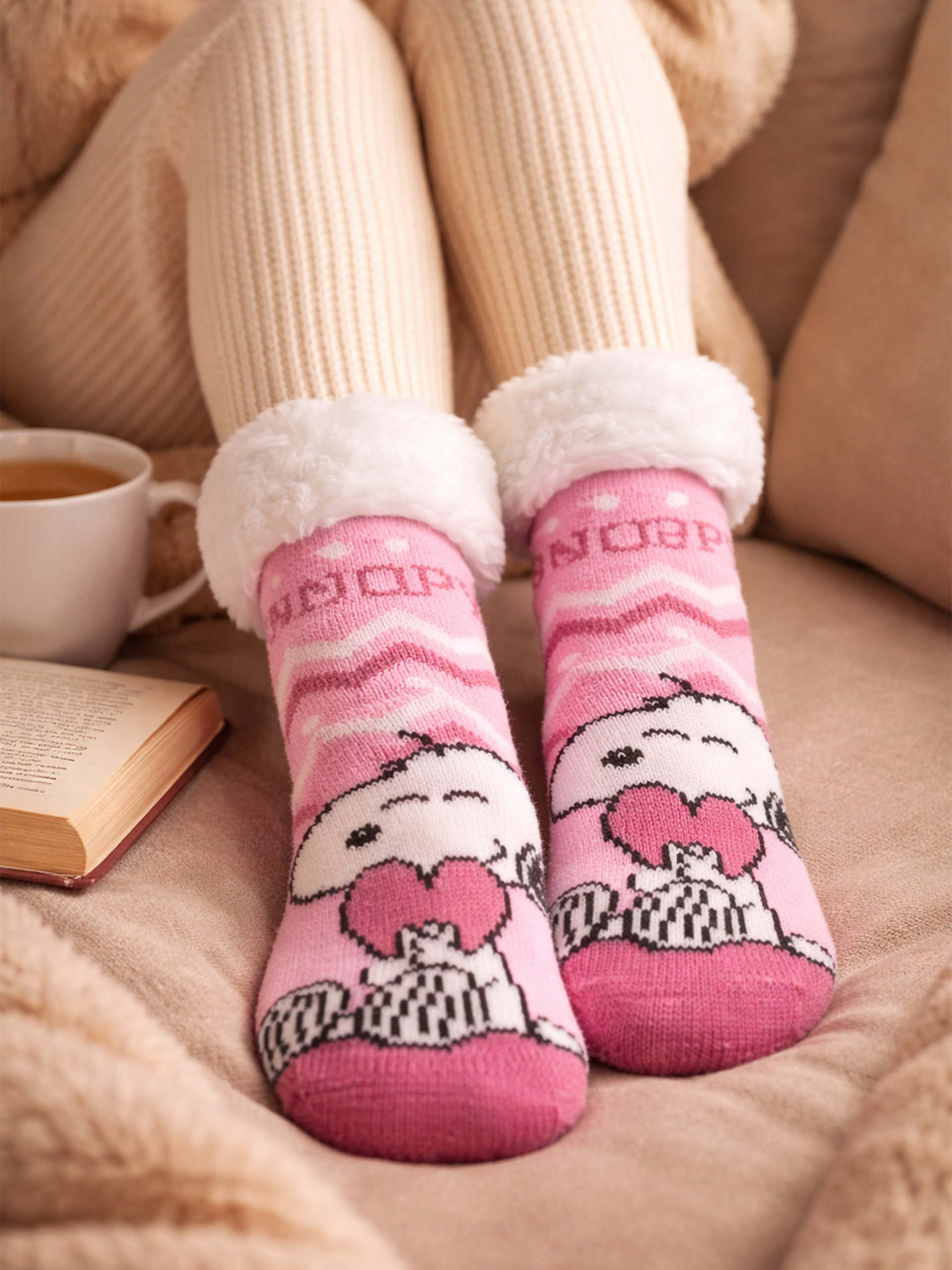 Rosa Socken mit Snoopy-Motiv, weißem Fellrand und Zickzackmuster.