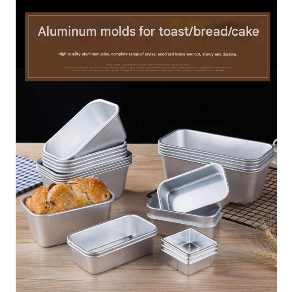 Mehrere Aluminium-Brotformen, eine mit Brot, auf einem Holztisch.