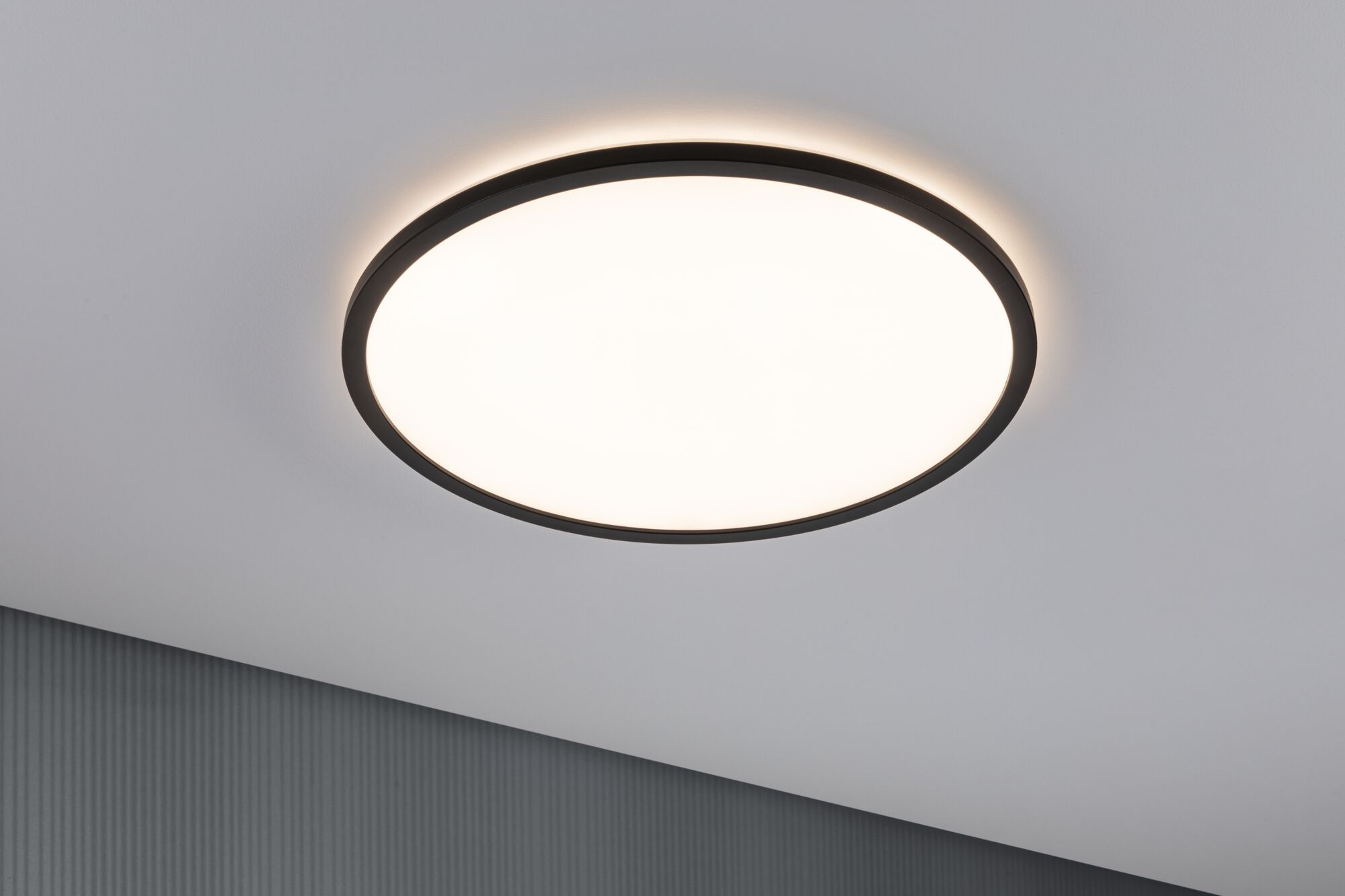 Una lampada da soffitto rotonda e scura con centro illuminato.