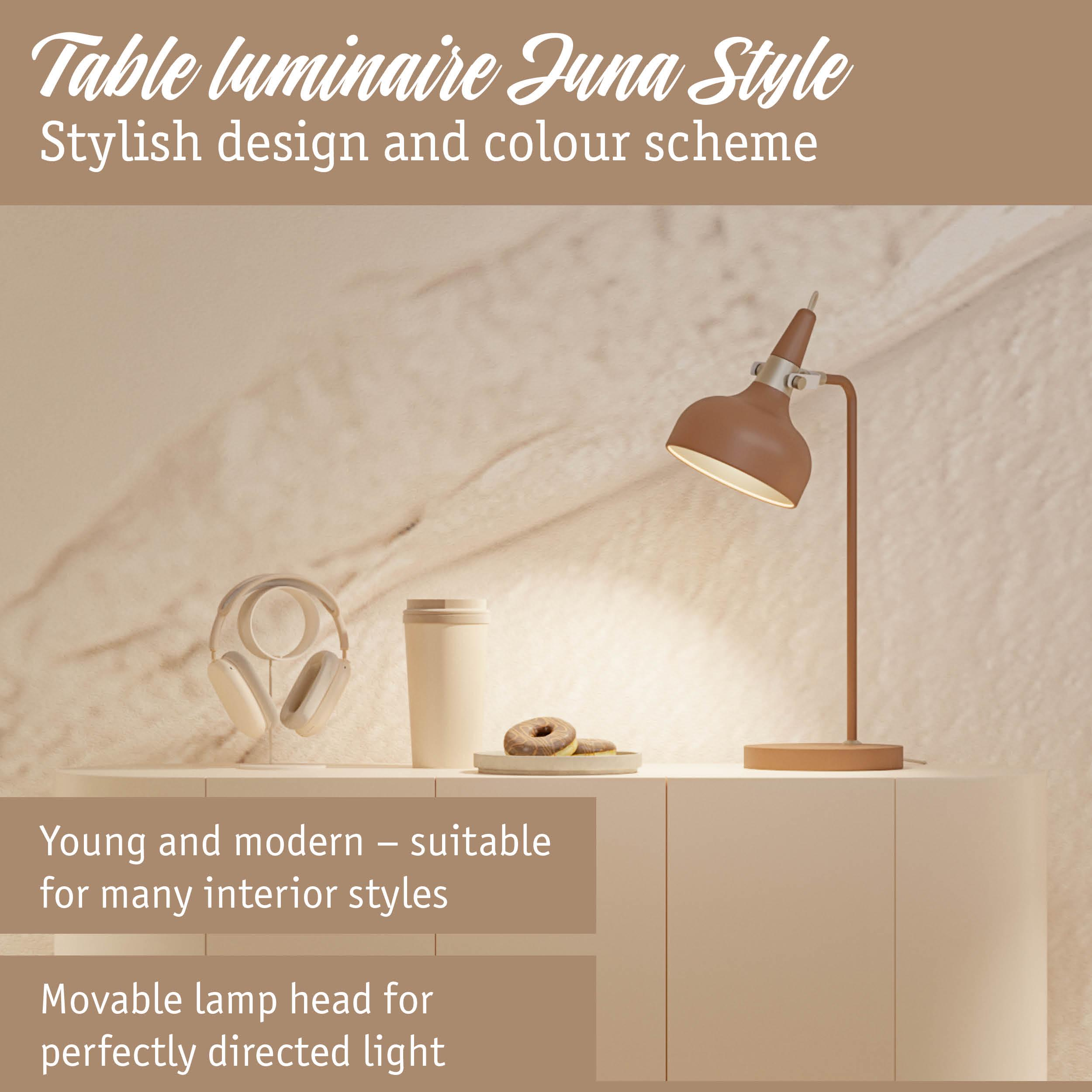 Brązowa lampa biurkowa, słuchawki, kubek i dwa pączki.