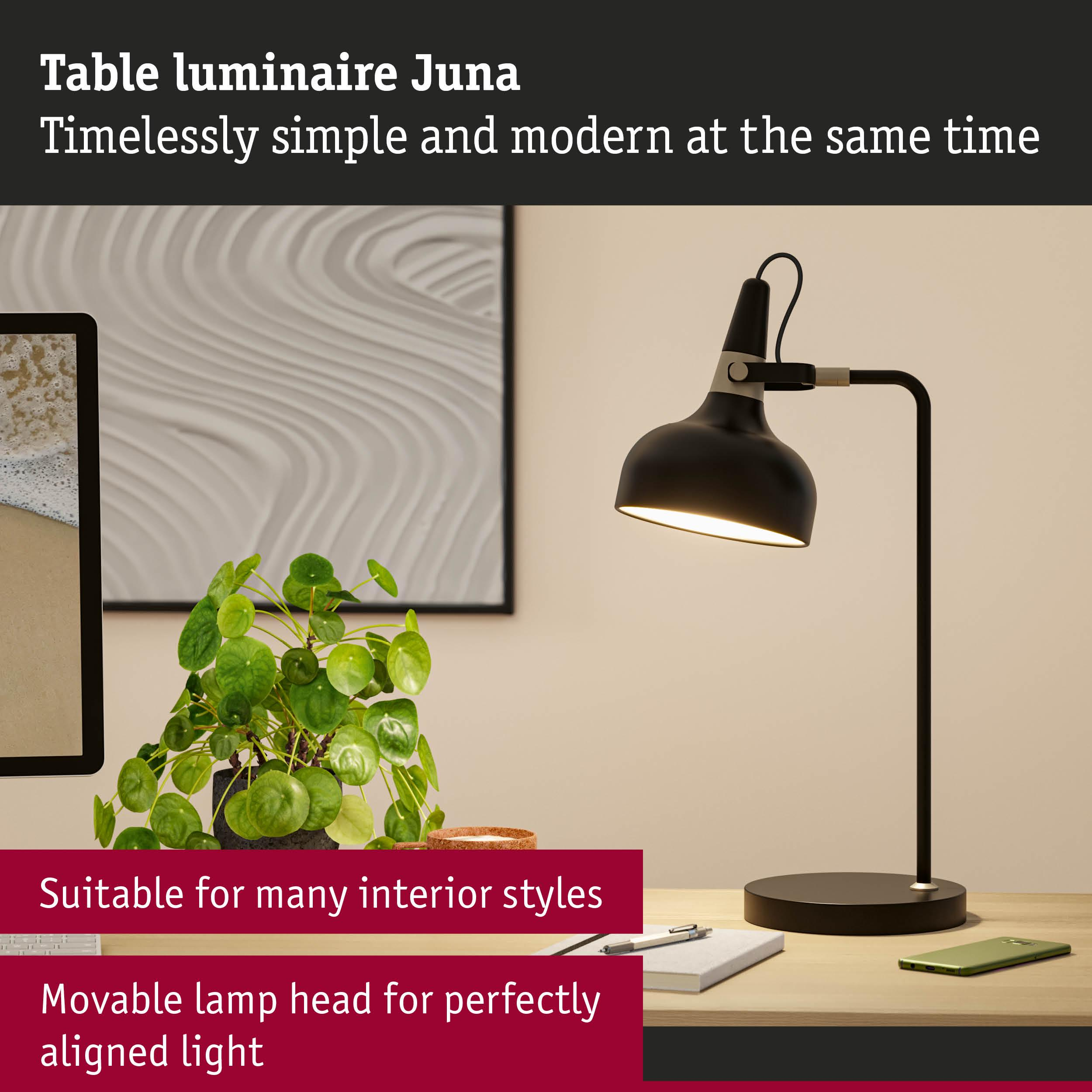 Czarna lampa biurkowa z regulowaną głowicą obok zielonego telefonu komórkowego.