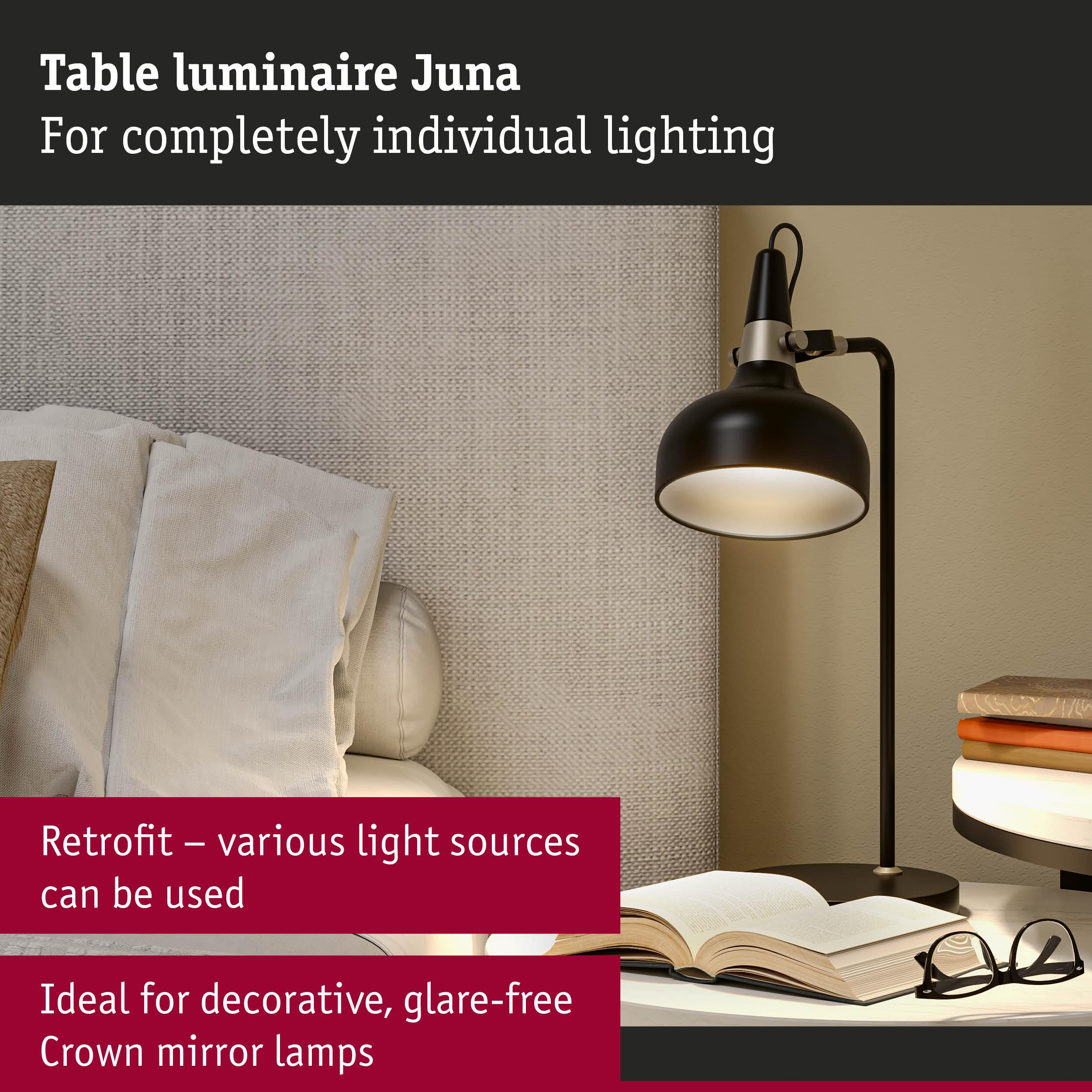 Czarna lampa biurkowa obok otwartej książki i okularów na stoliku nocnym.