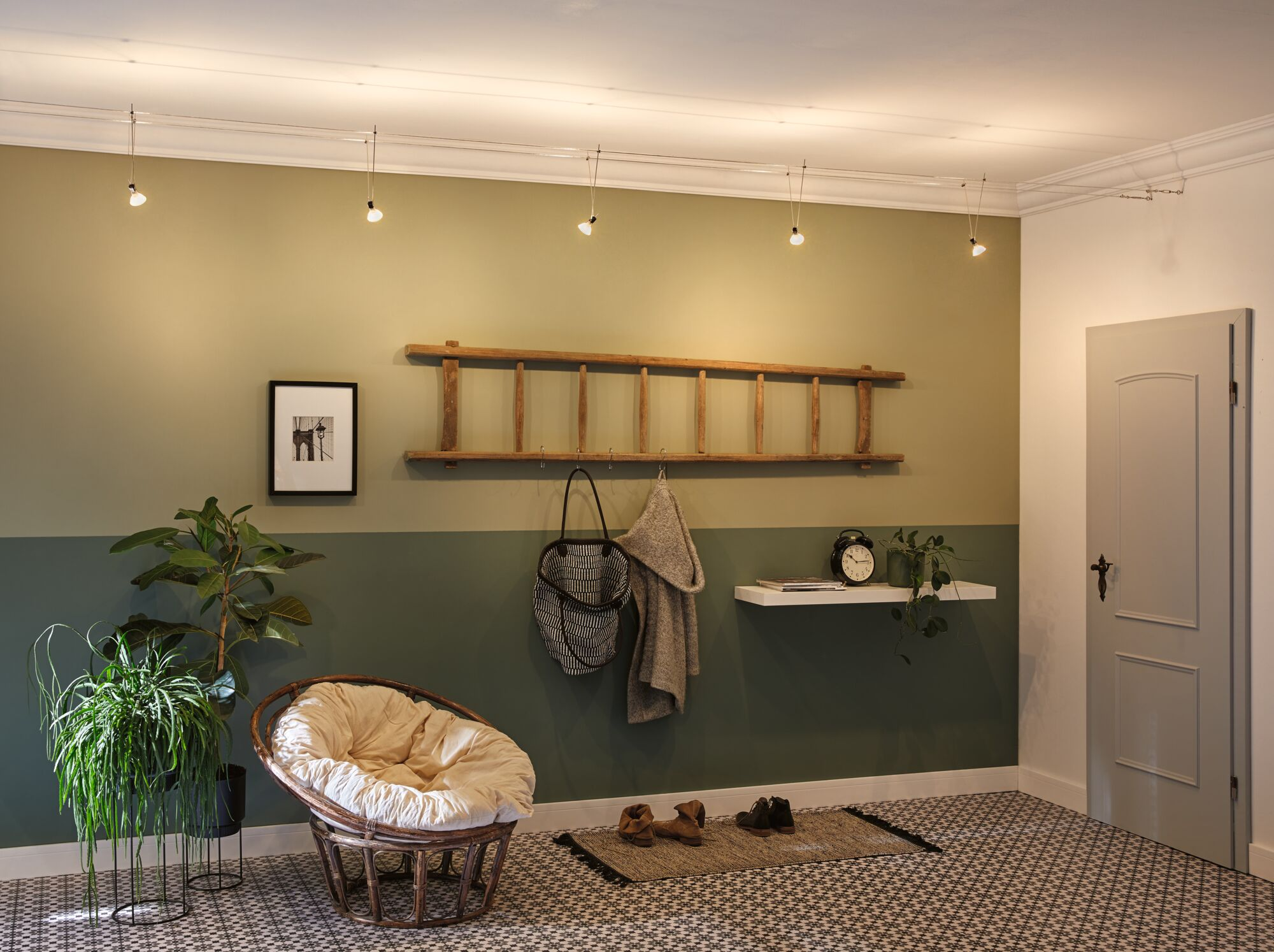 Przedpokój z miejscem do siedzenia, wieszakiem, roślinami i obrazem.
