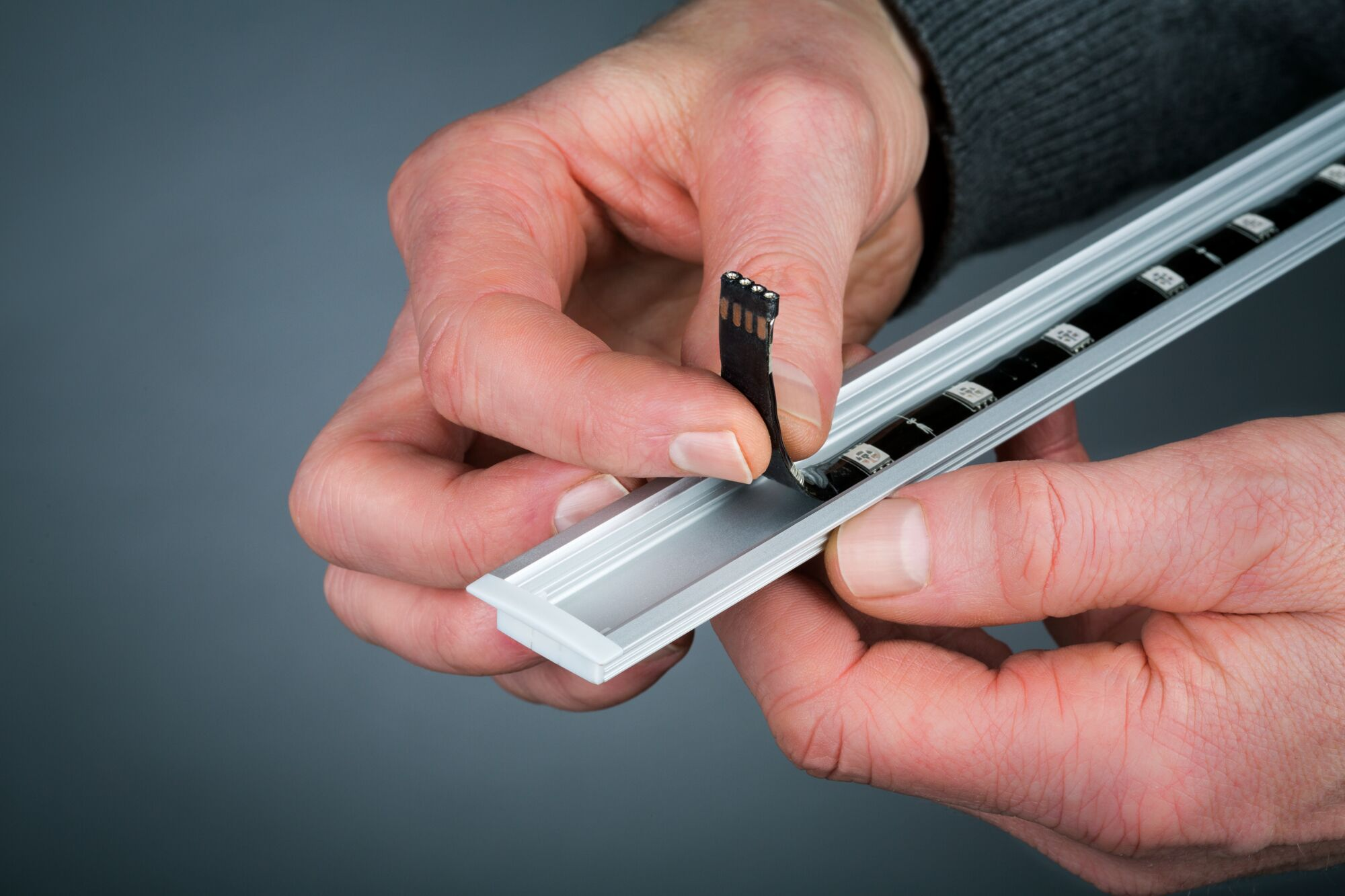 Ręce montujące pasek LED do profilu aluminiowego.