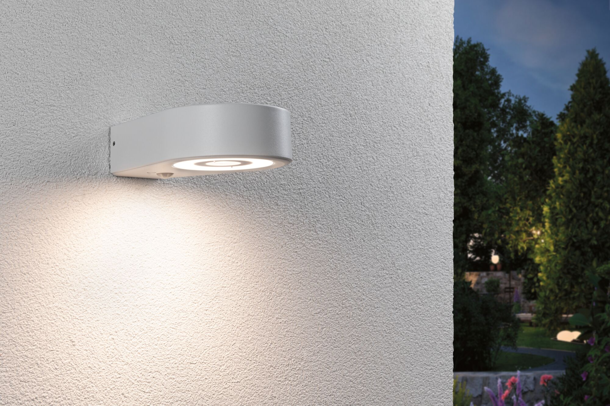 Biała lampa ścienna oświetla teksturowaną białą ścianę.