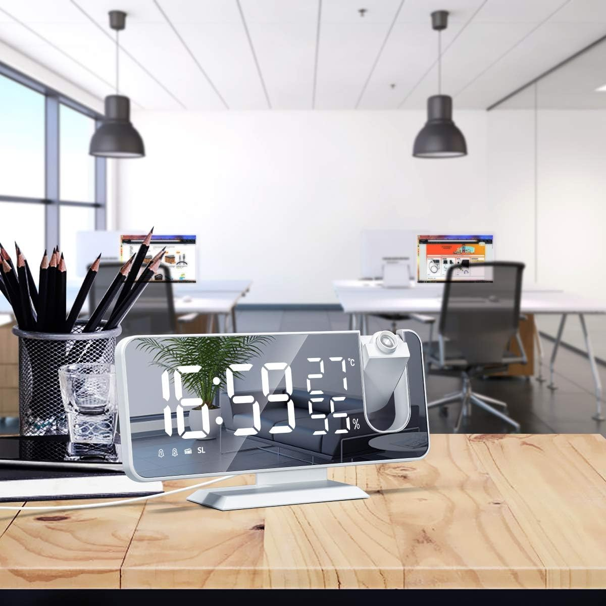 Digitaluhr mit Projektion auf einem Schreibtisch im Büro. Zeigt 16:59, 27°C und 55% an.