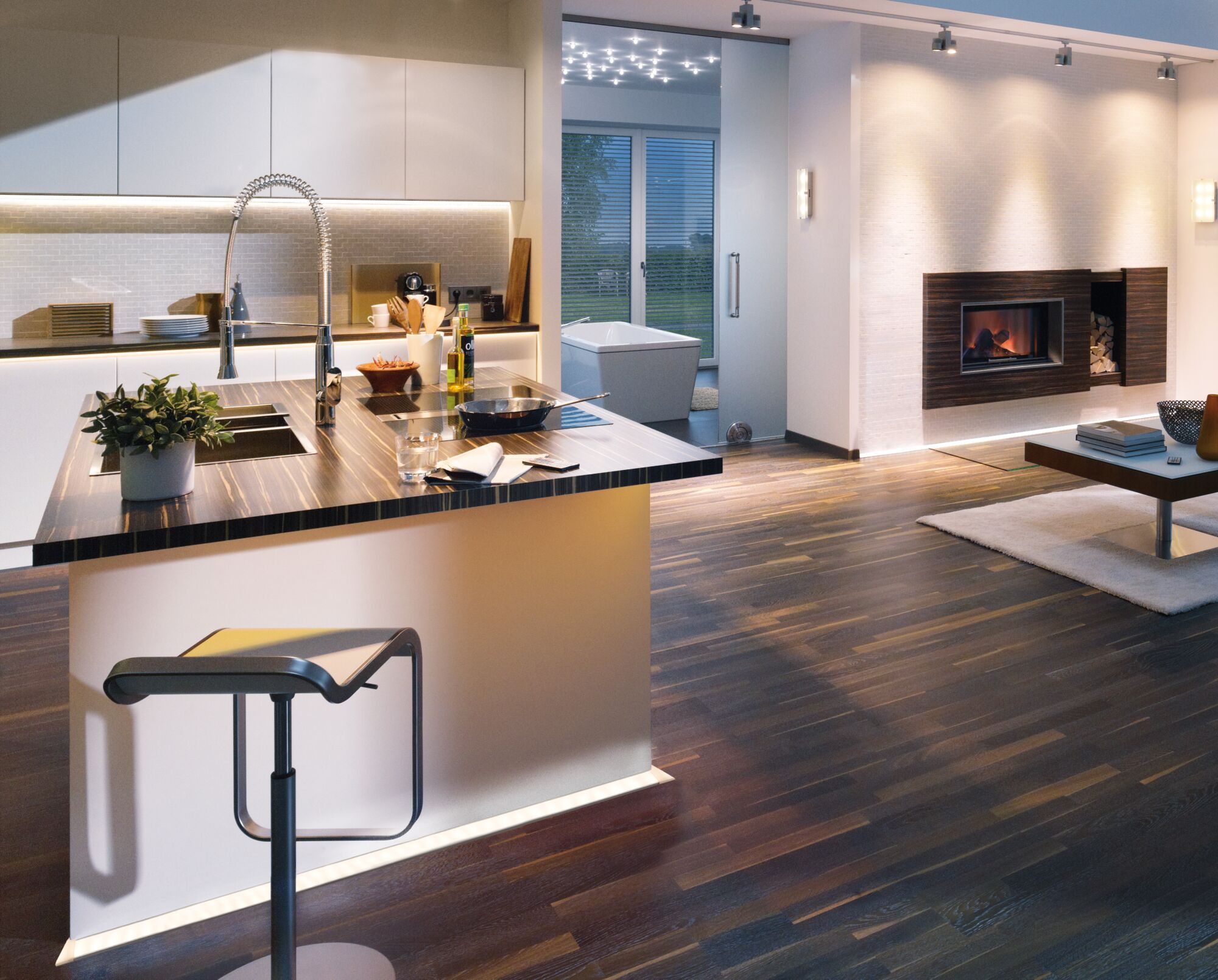 Nowoczesna kuchnia i salon z kominkiem, widoczna wanna.