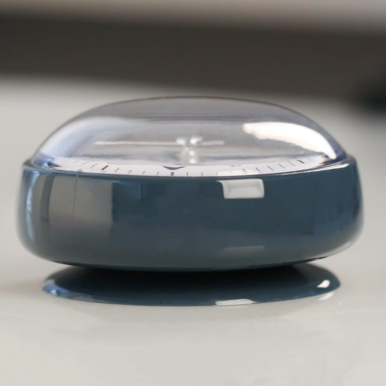 Ein grauer Küchentimer mit transparenter Kuppel und Skala.