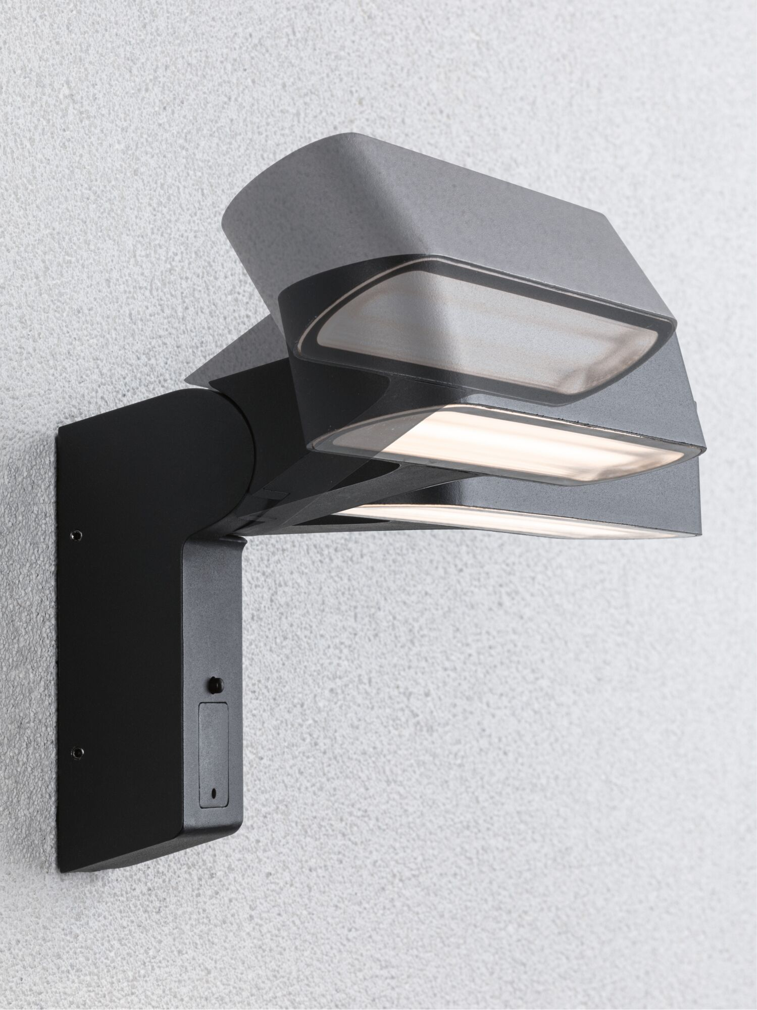 Moderne schwarze Wandleuchte mit zwei Lichtern an einer strukturierten weißen Wand.