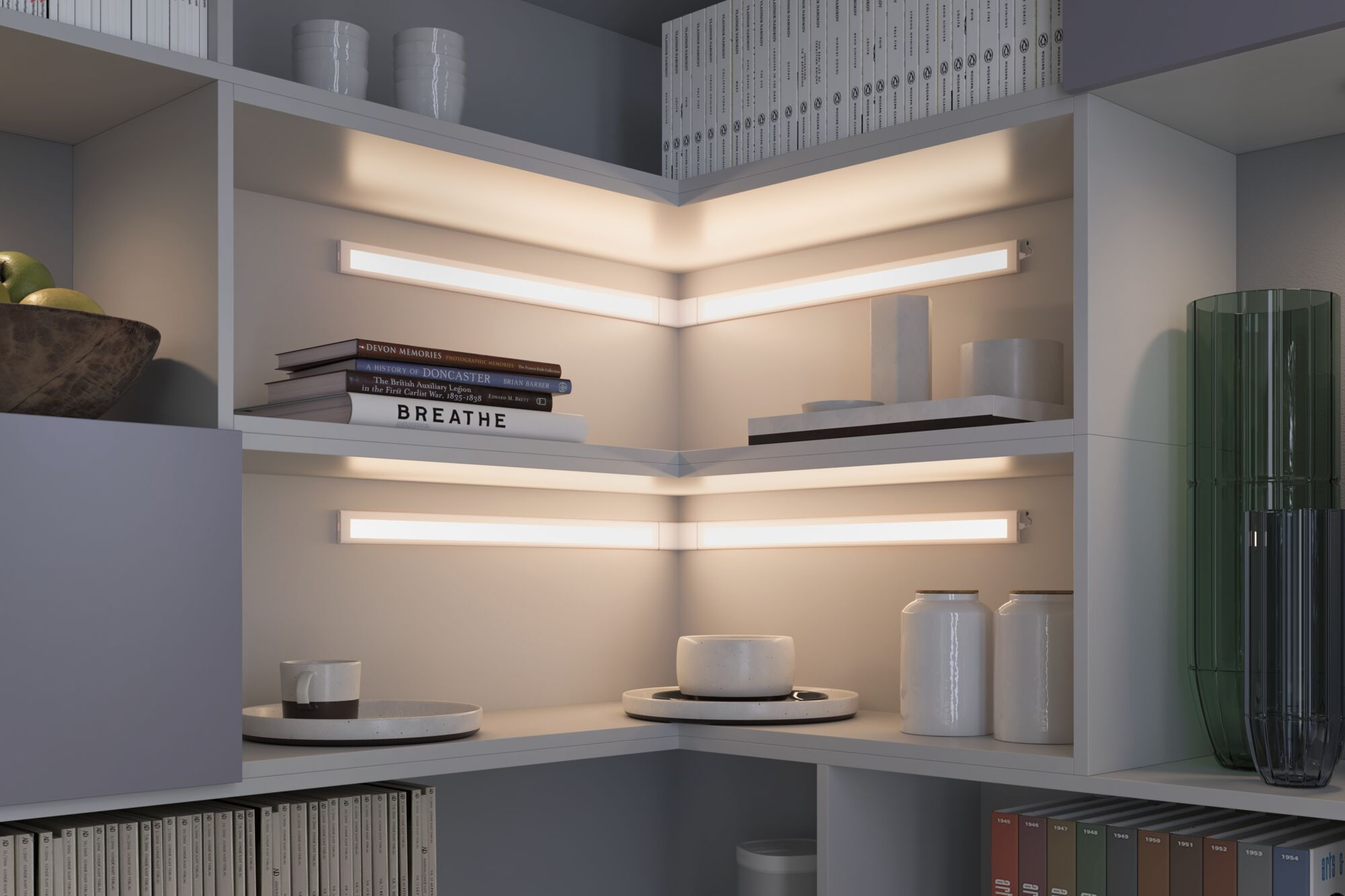 Ein Bücherregal mit Büchern, Obst und Dekoration, beleuchtet von LED-Streifen.