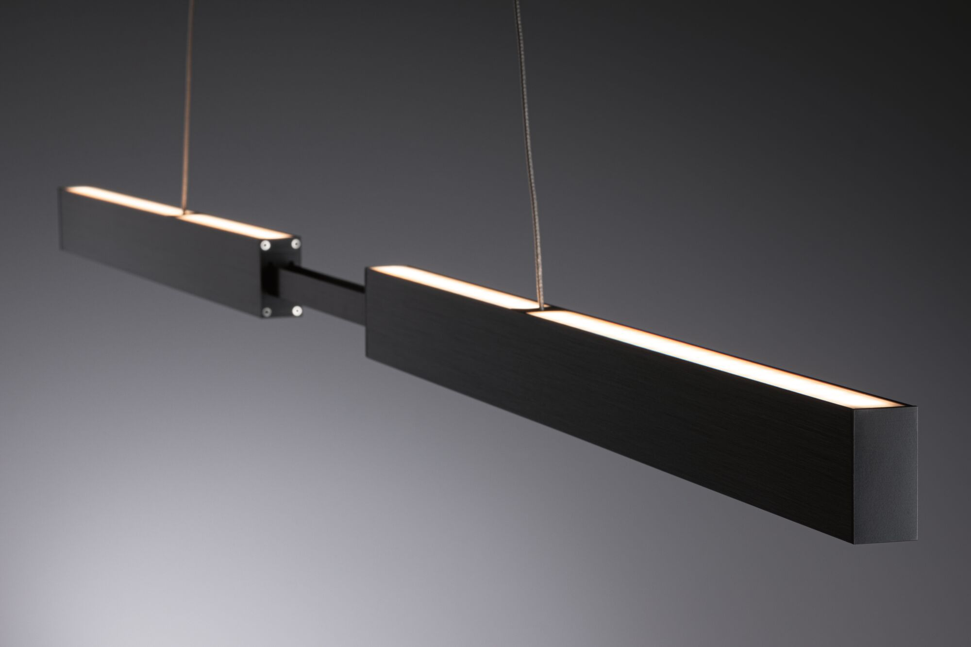 Dwie czarne, prostokątne lampy wiszące ze światłami pośrodku.