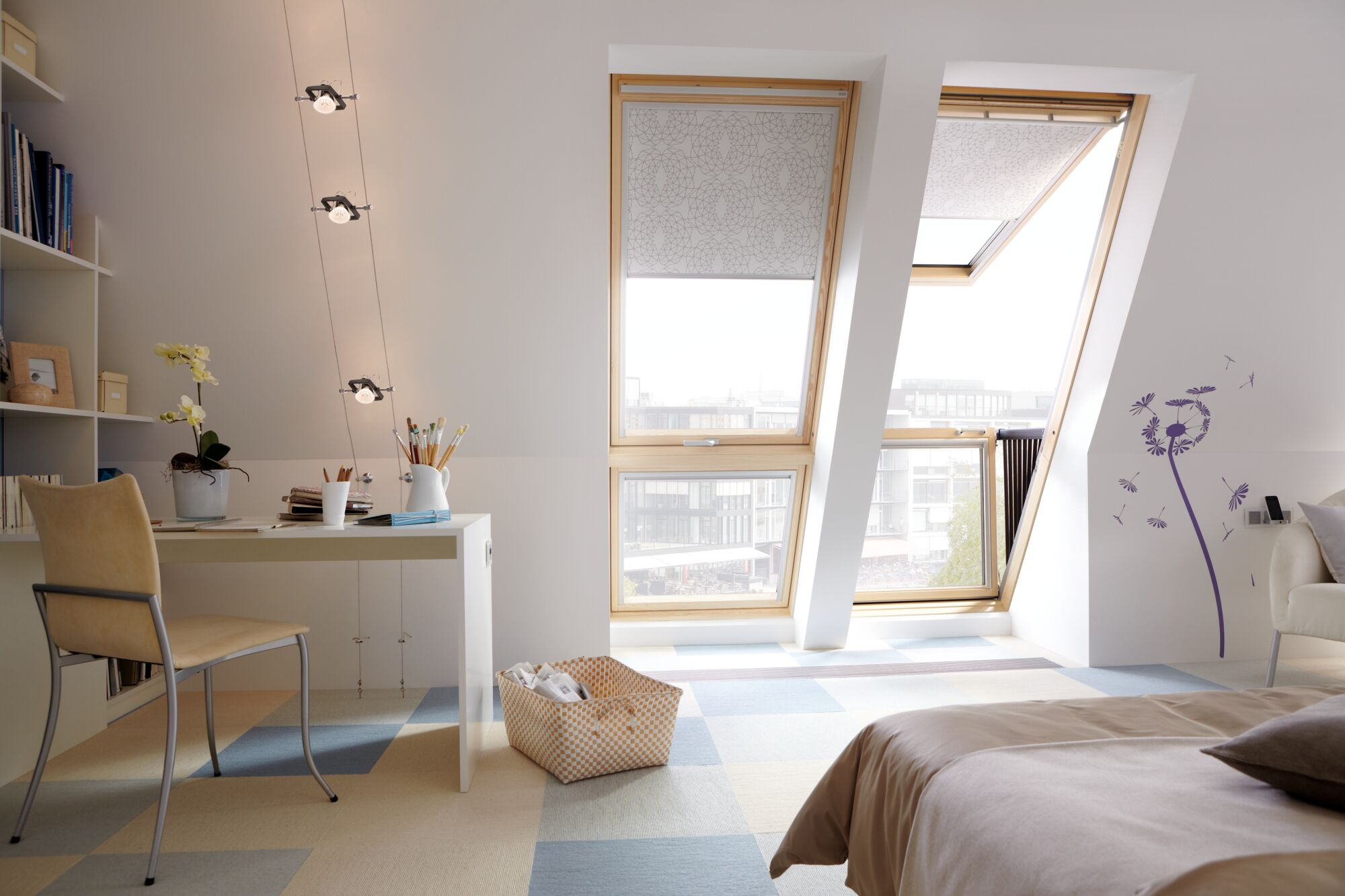 Sypialnia z oknami połaciowymi, biurkiem, krzesłem i łóżkiem.