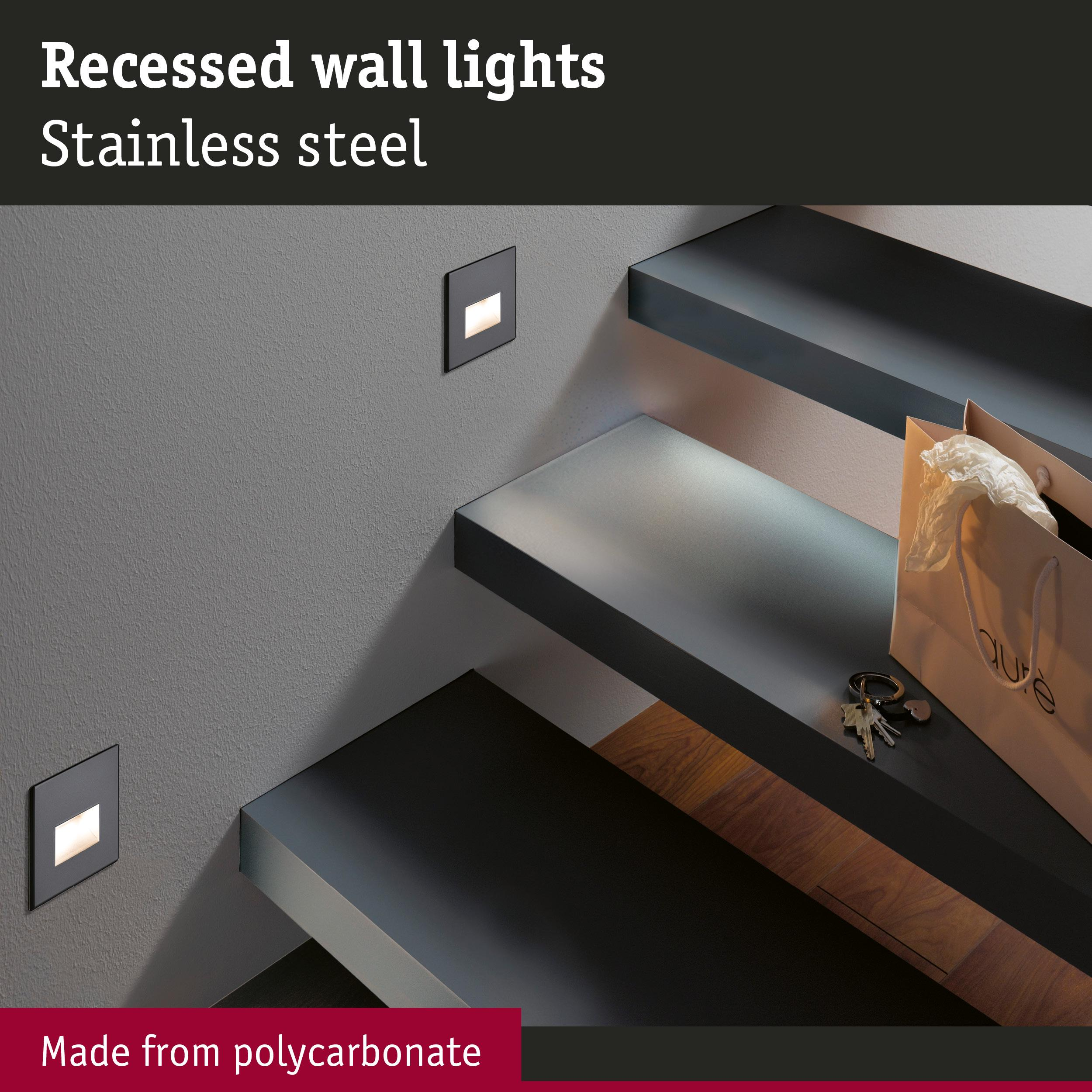 Stopnie schodów z wpuszczonymi kinkietami, torbą na zakupy i pękiem kluczy.