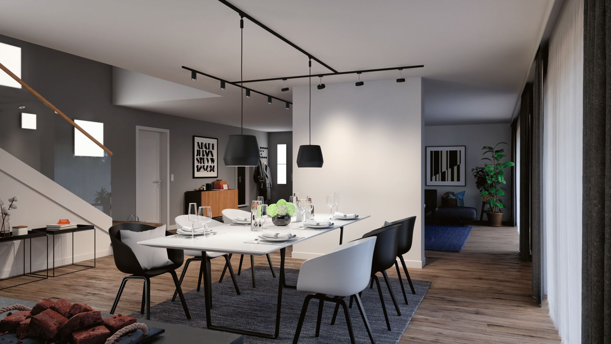 Modernes Esszimmer mit weißem Tisch, schwarzen und weißen Stühlen und schwarzen Pendelleuchten.