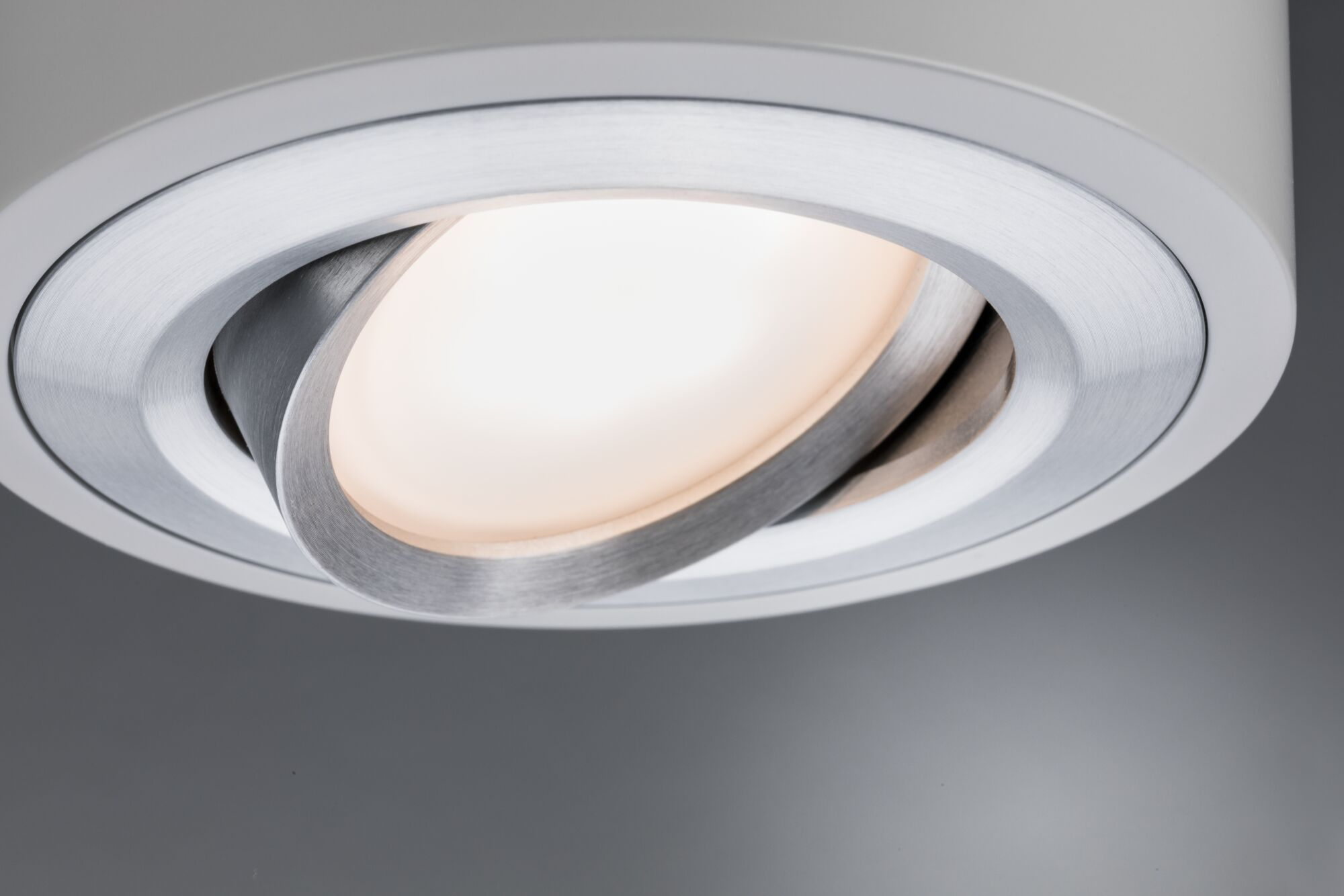 Un faretto da incasso con anello metallico regolabile e luce brillante.