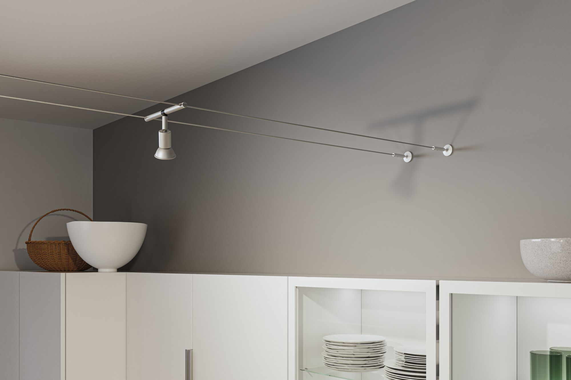Ein moderner Lichtschienenspot mit weißem Lampenschirm über einem weißen Schrank.