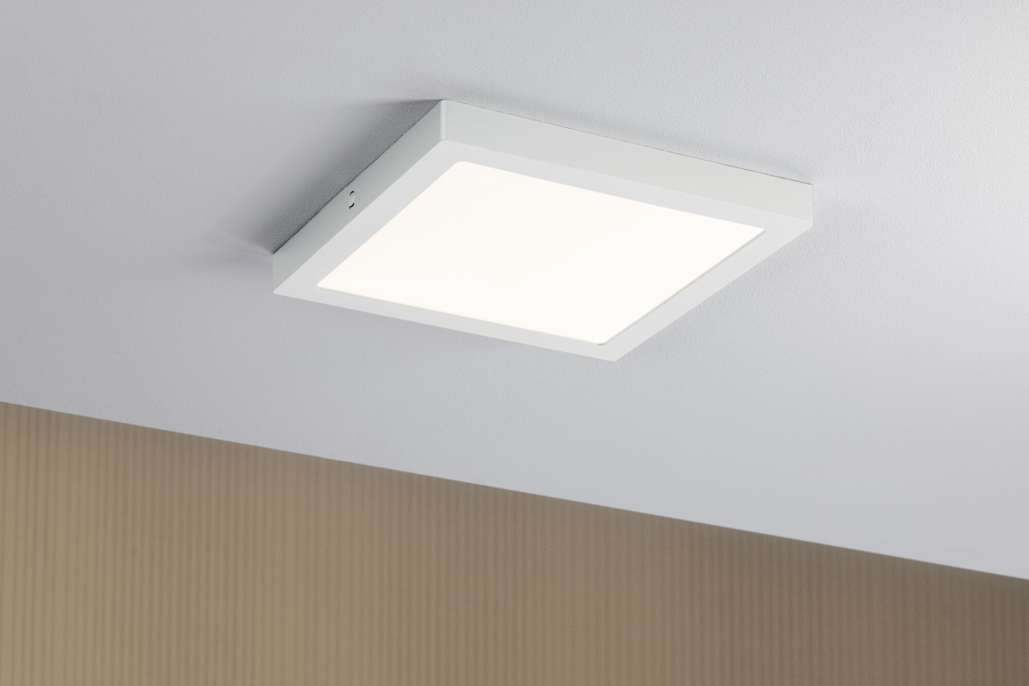Una plafoniera quadrata bianca illumina un soffitto bianco.