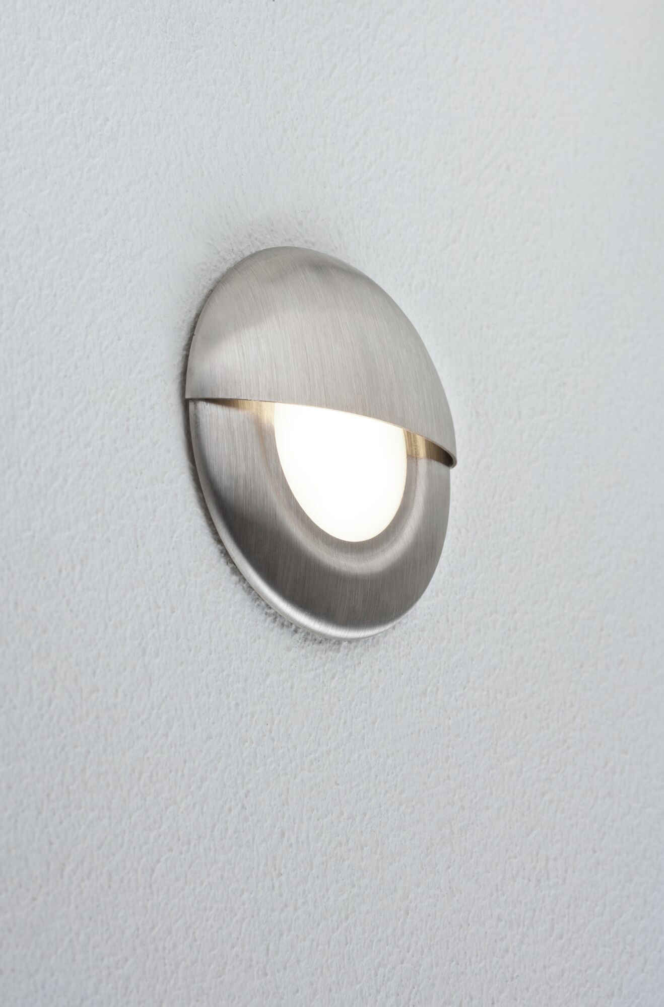 Eine gebürstete Metallwandleuchte mit einem ovalen, nach unten gerichteten Licht.