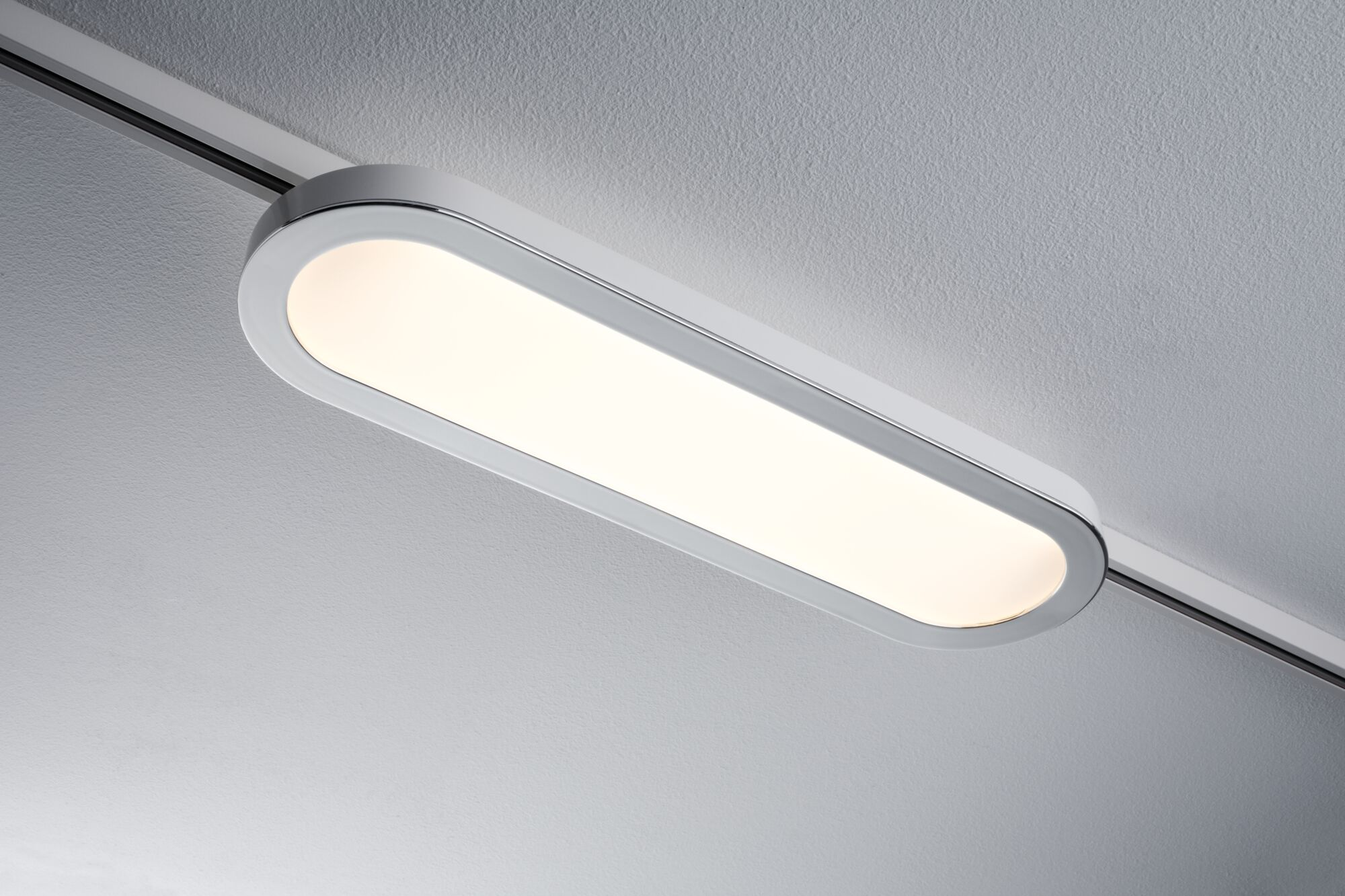 Una lampada da soffitto lunga e bianca con cornice argentata su un binario.