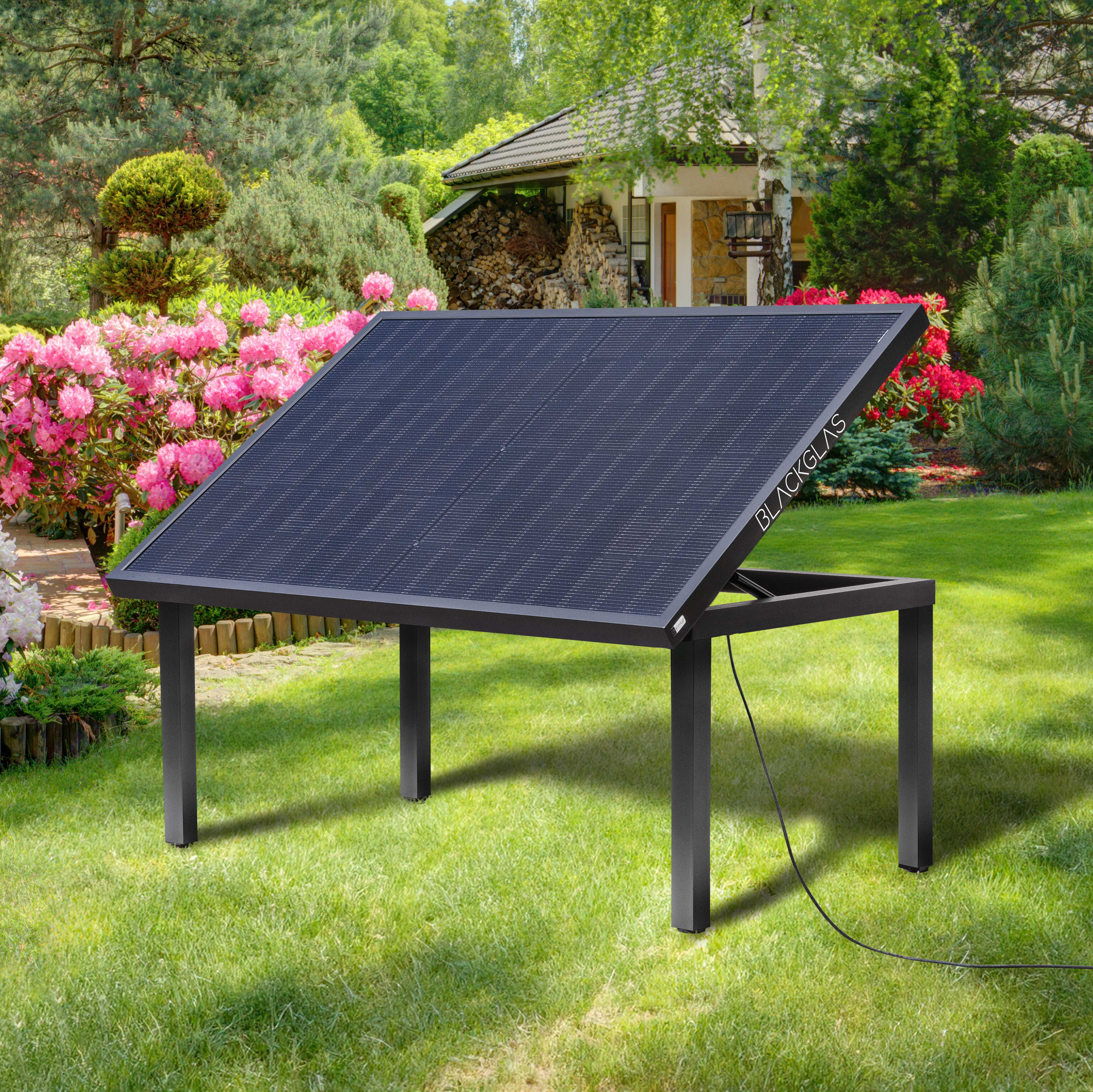 Ein schwarzes Solarpanel steht auf einem Metallrahmen im Garten.