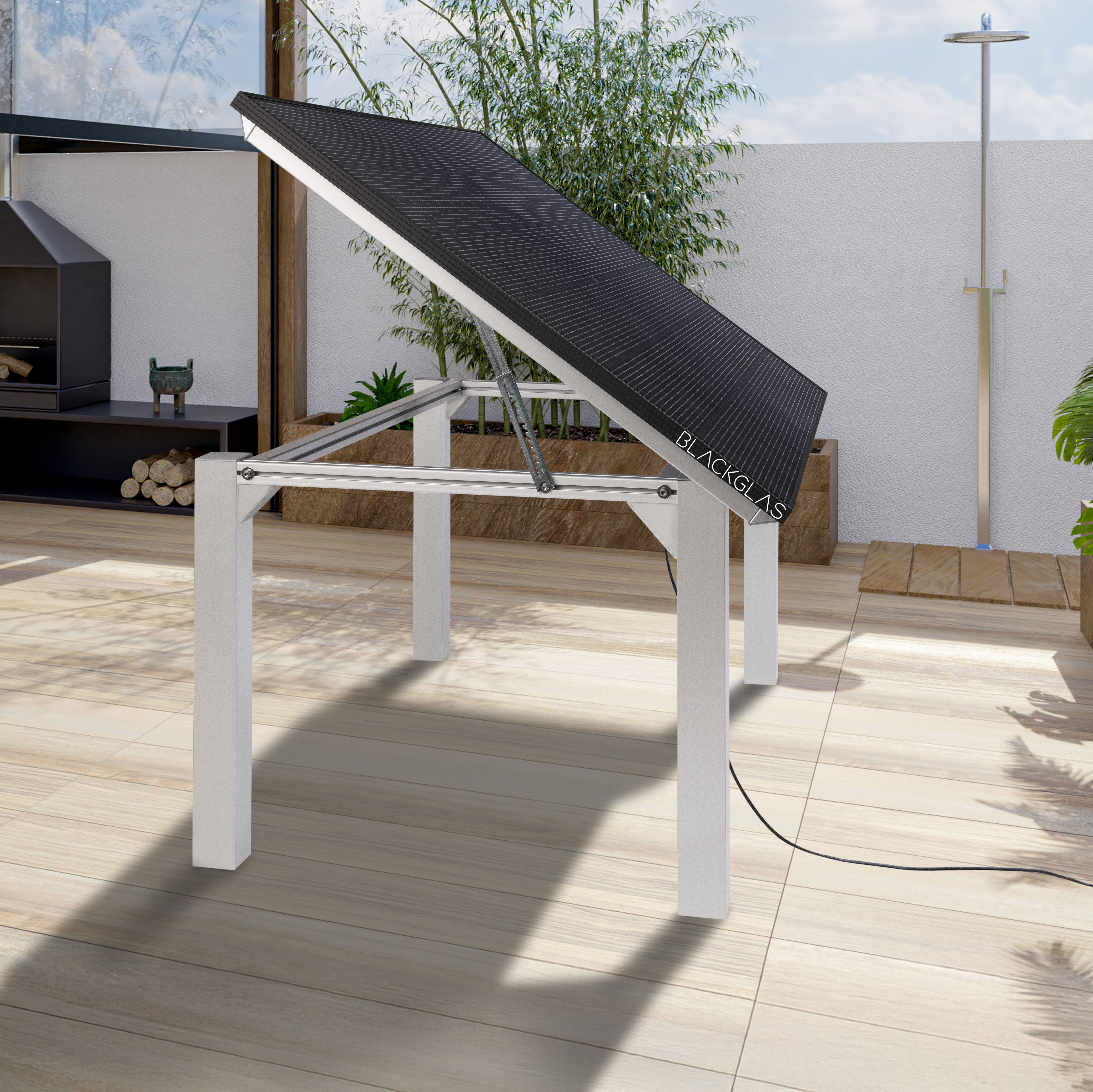 Ein Tisch mit einem schwarzen Solarpanel steht auf einer Holzterrasse. Ein Grill ist sichtbar.