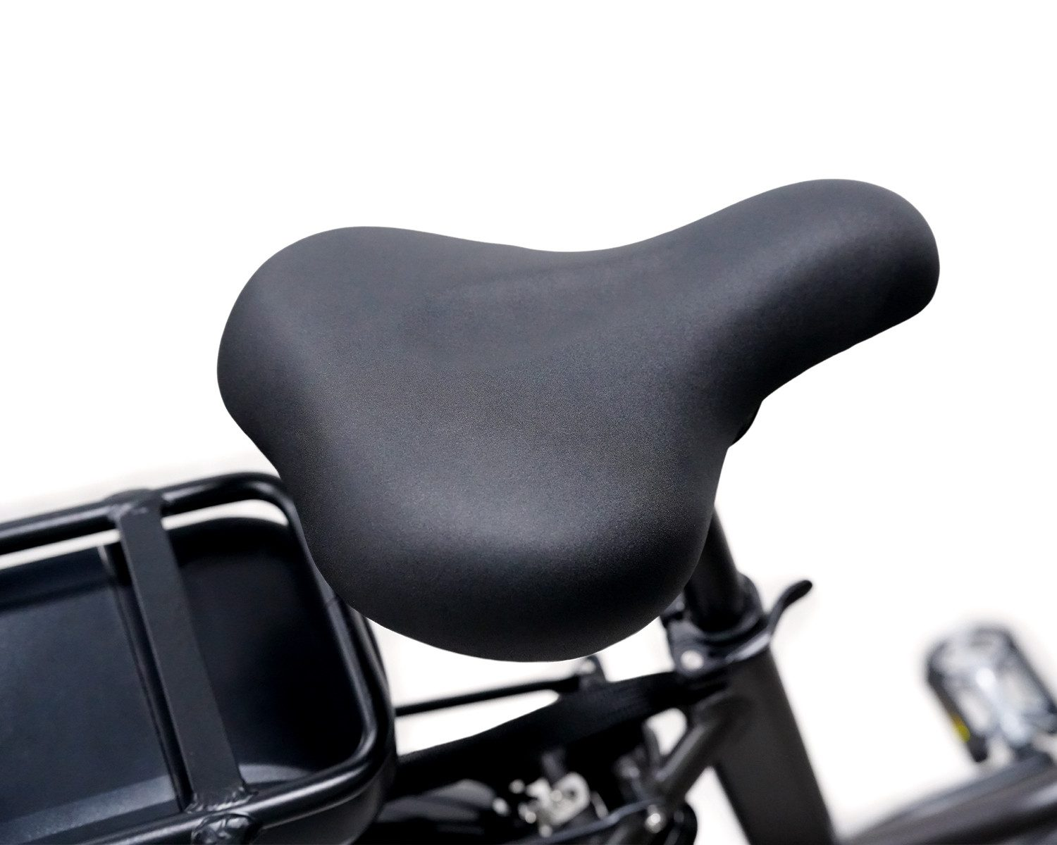 Sella da bicicletta nera con portapacchi sullo sfondo su superficie bianca.
