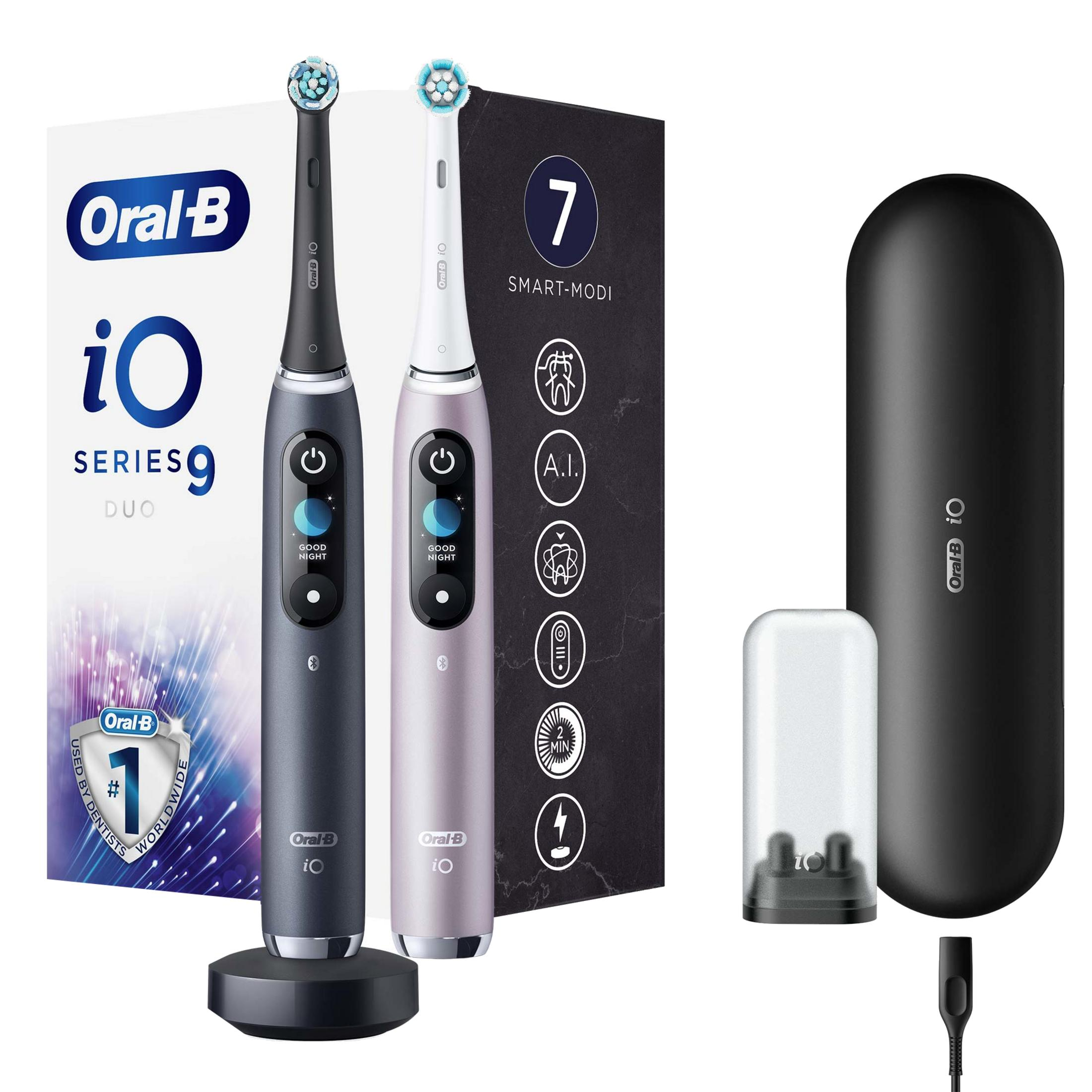 İki Oral-B iO Series 9 Duo diş fırçası, şarj istasyonu, seyahat çantası ve şarj cihazı.