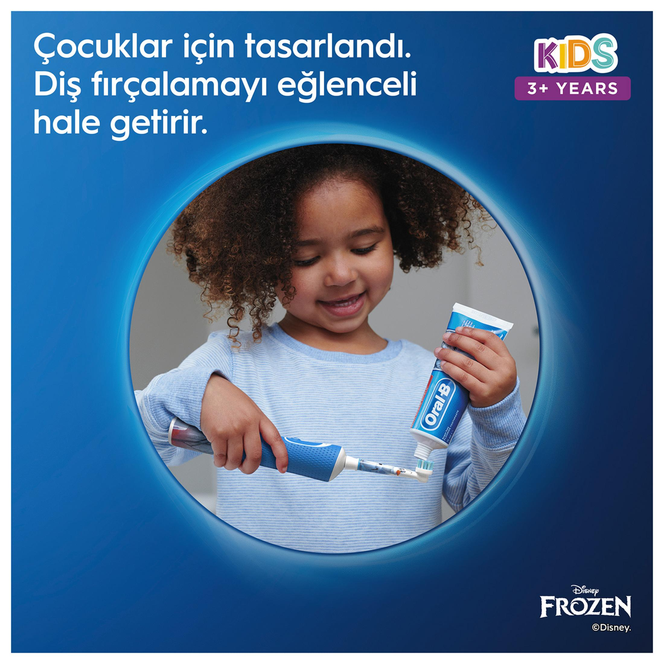 Kıvırcık saçlı küçük bir kız diş fırçası ve diş macunu tutuyor.