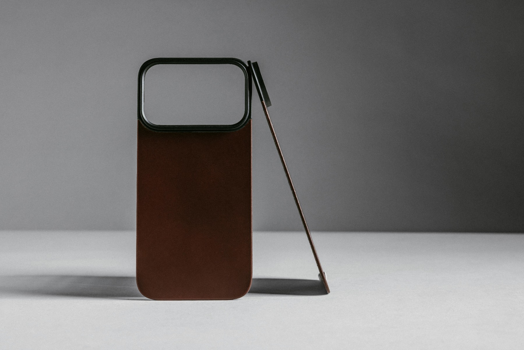 Una cover per telefono marrone con bordo nero sta su un tavolo.
