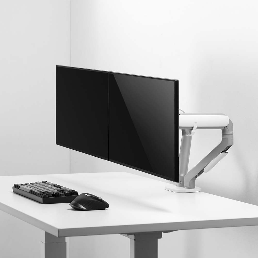 Zwei schwarze Monitore auf einem silbernen Arm über einer Tastatur und Maus.