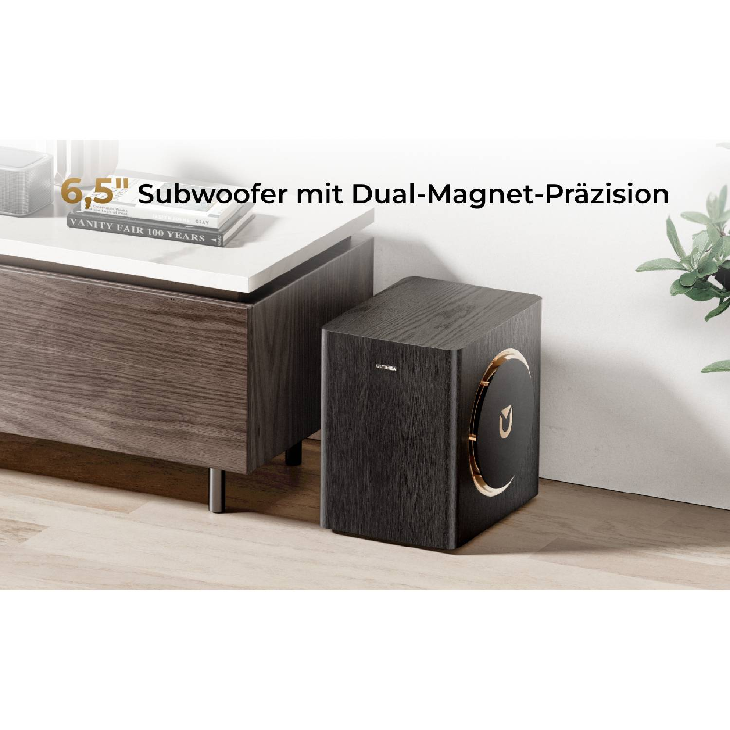 Un subwoofer en bois sombre avec des accents dorés est posé sur un parquet.