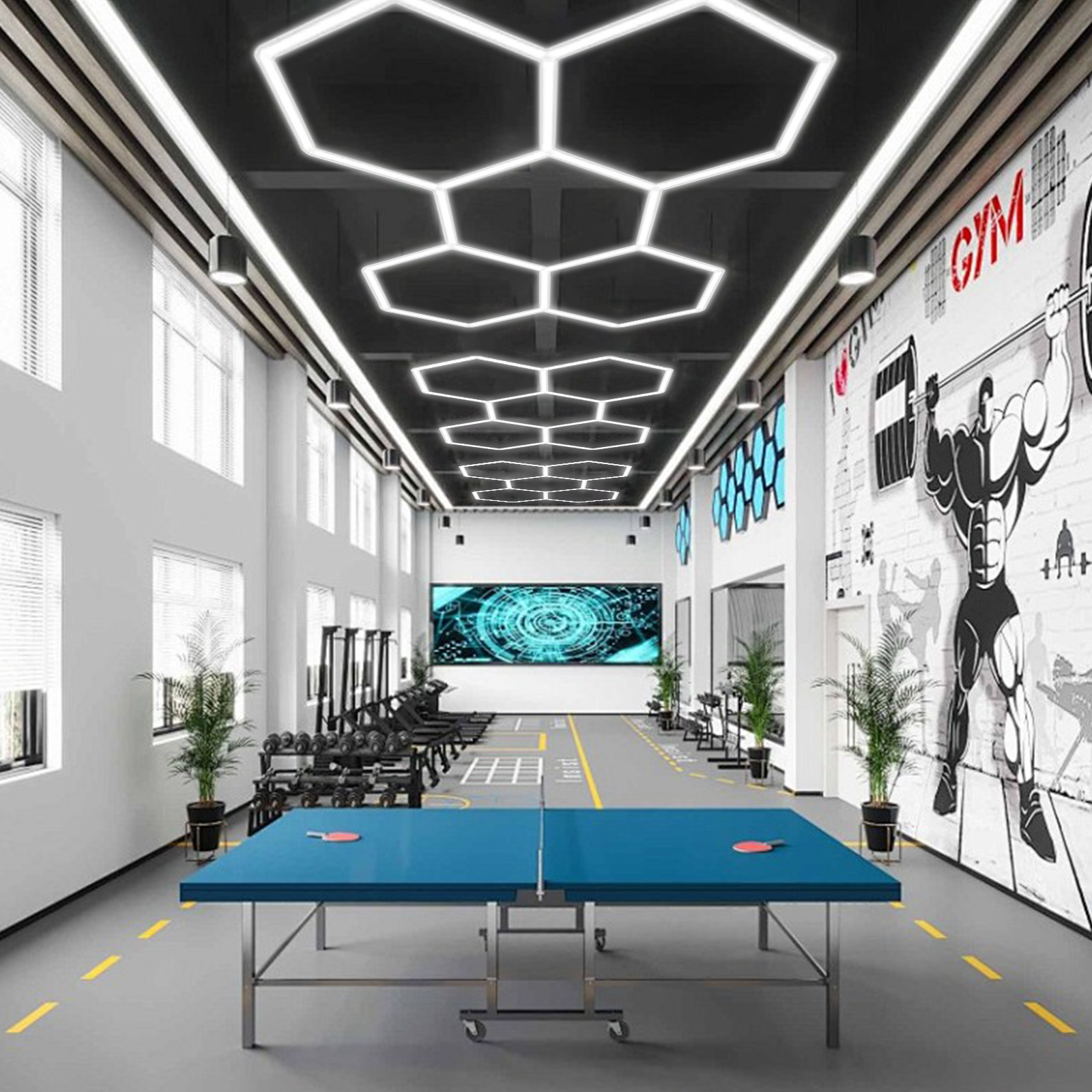Un gimnasio con mesa de ping pong, pesas, cintas de correr y pantalla grande.